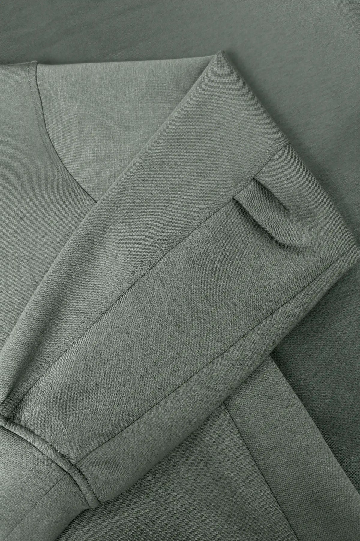 Close-up of women’s sage grey knit polo sweatshirt showing the structured sleeve and wide cuff detail