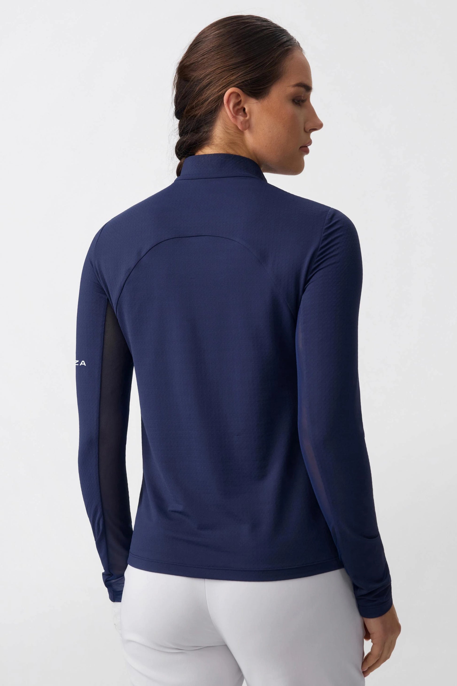 Back view of a navy long sleeve zip neck golf top with a sleek fitted silhouette