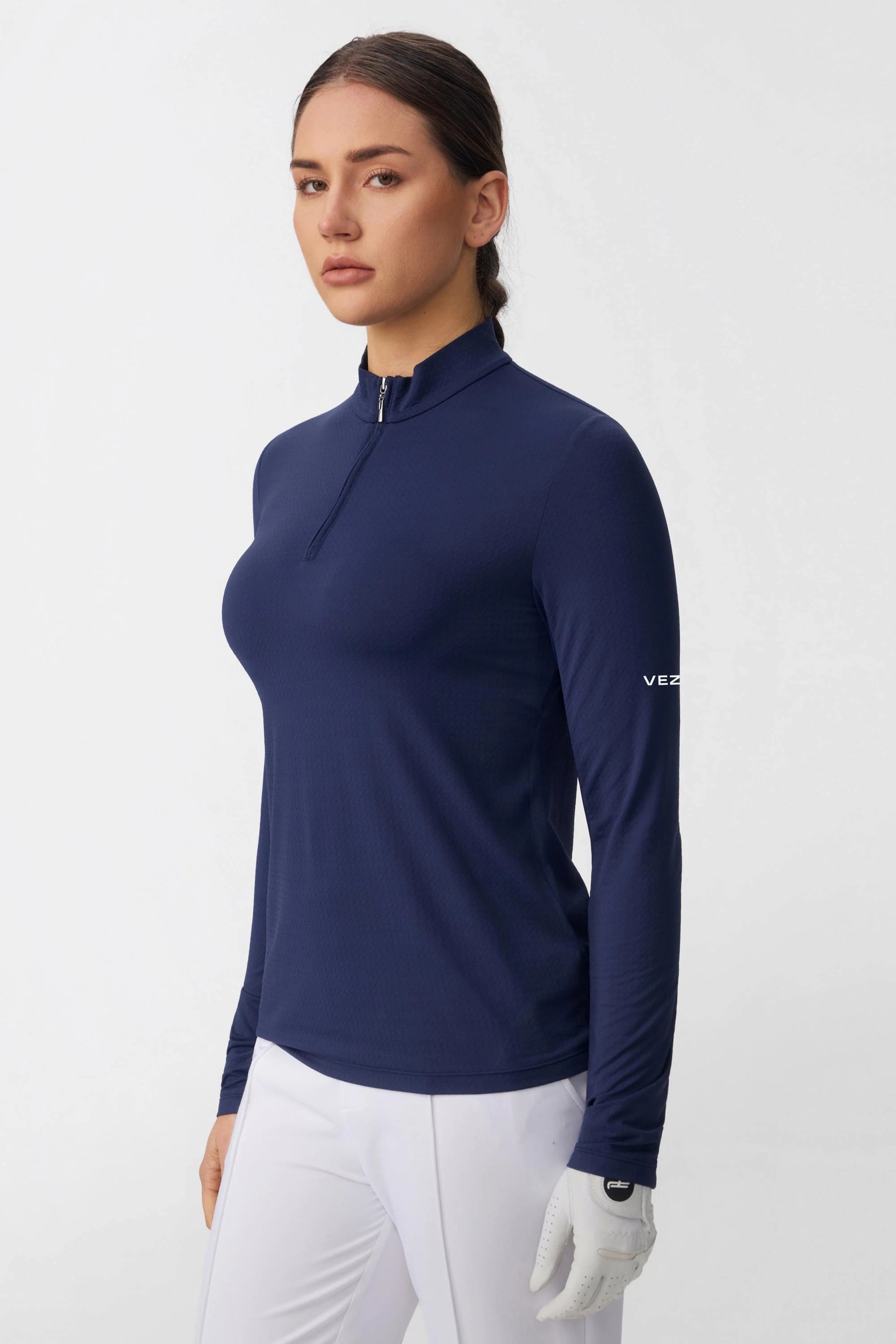Side view of a navy long sleeve zip neck golf top showing a streamlined athletic fit