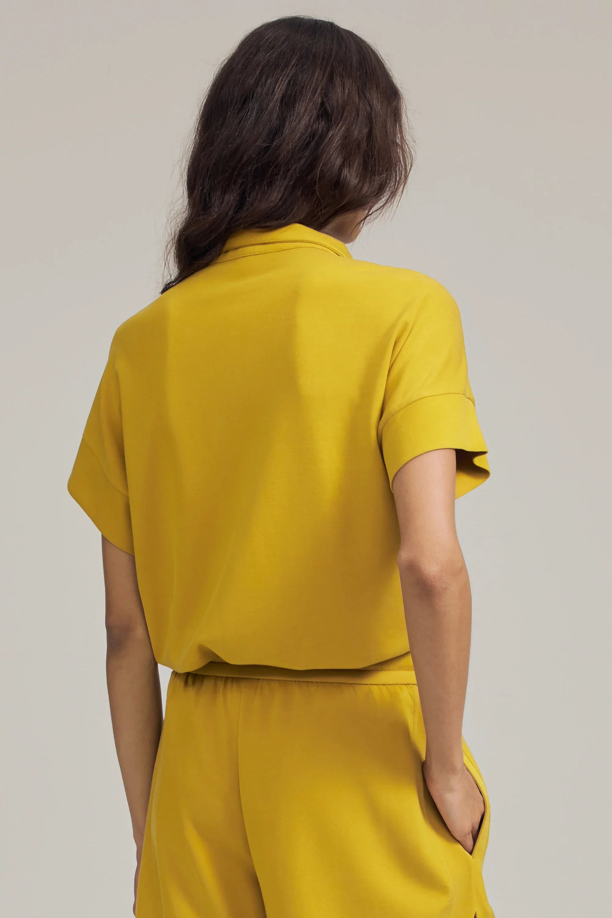 Back view of women’s marigold performance quarter-zip top with relaxed fit