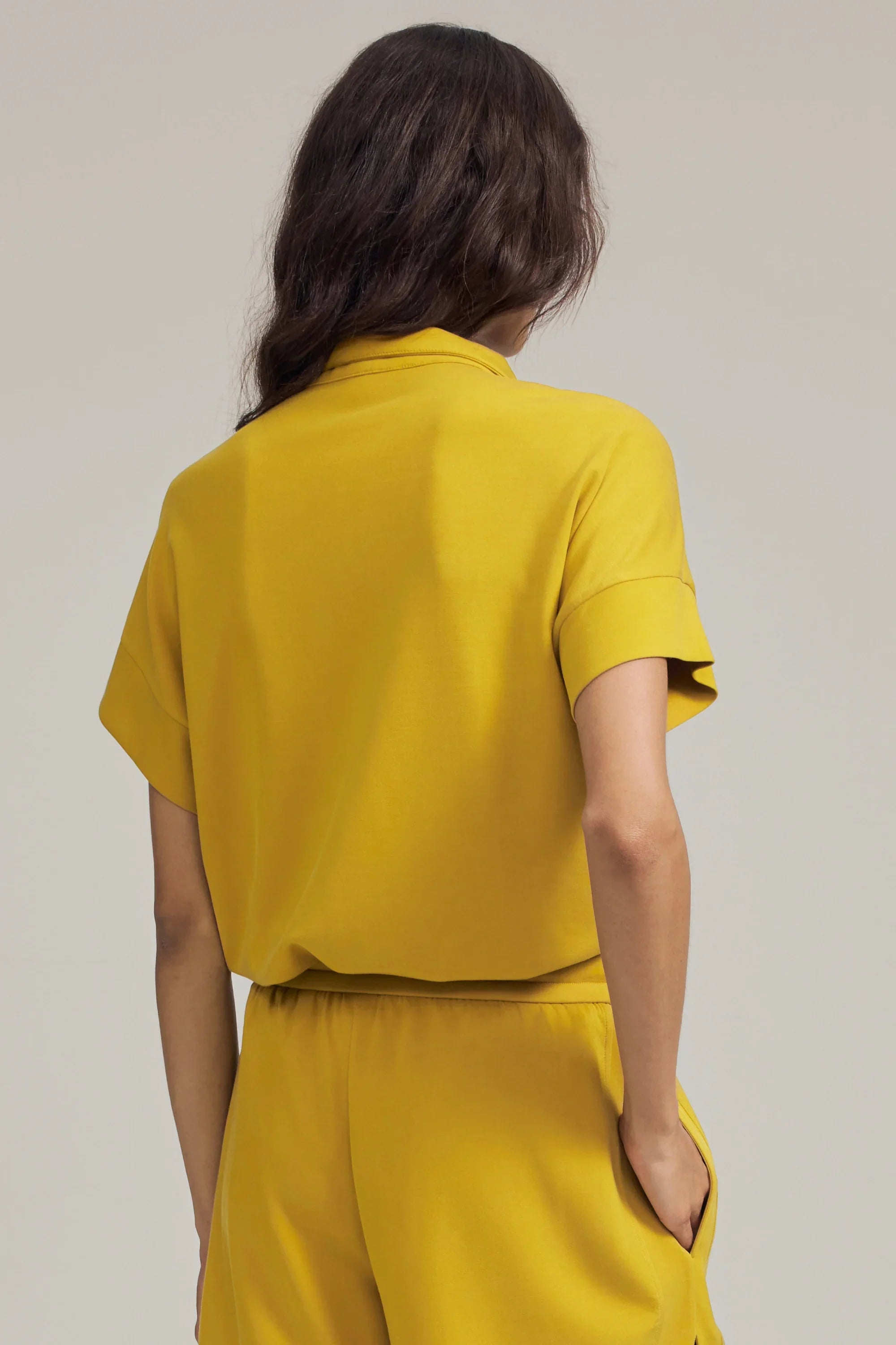Back view of women’s marigold performance quarter-zip top with relaxed fit