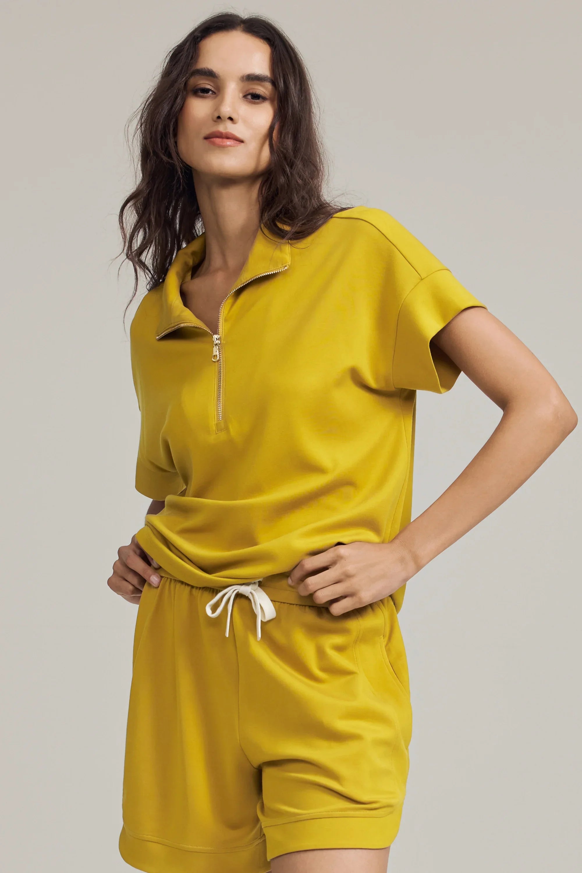 Women’s marigold performance quarter-zip top paired with matching relaxed shorts