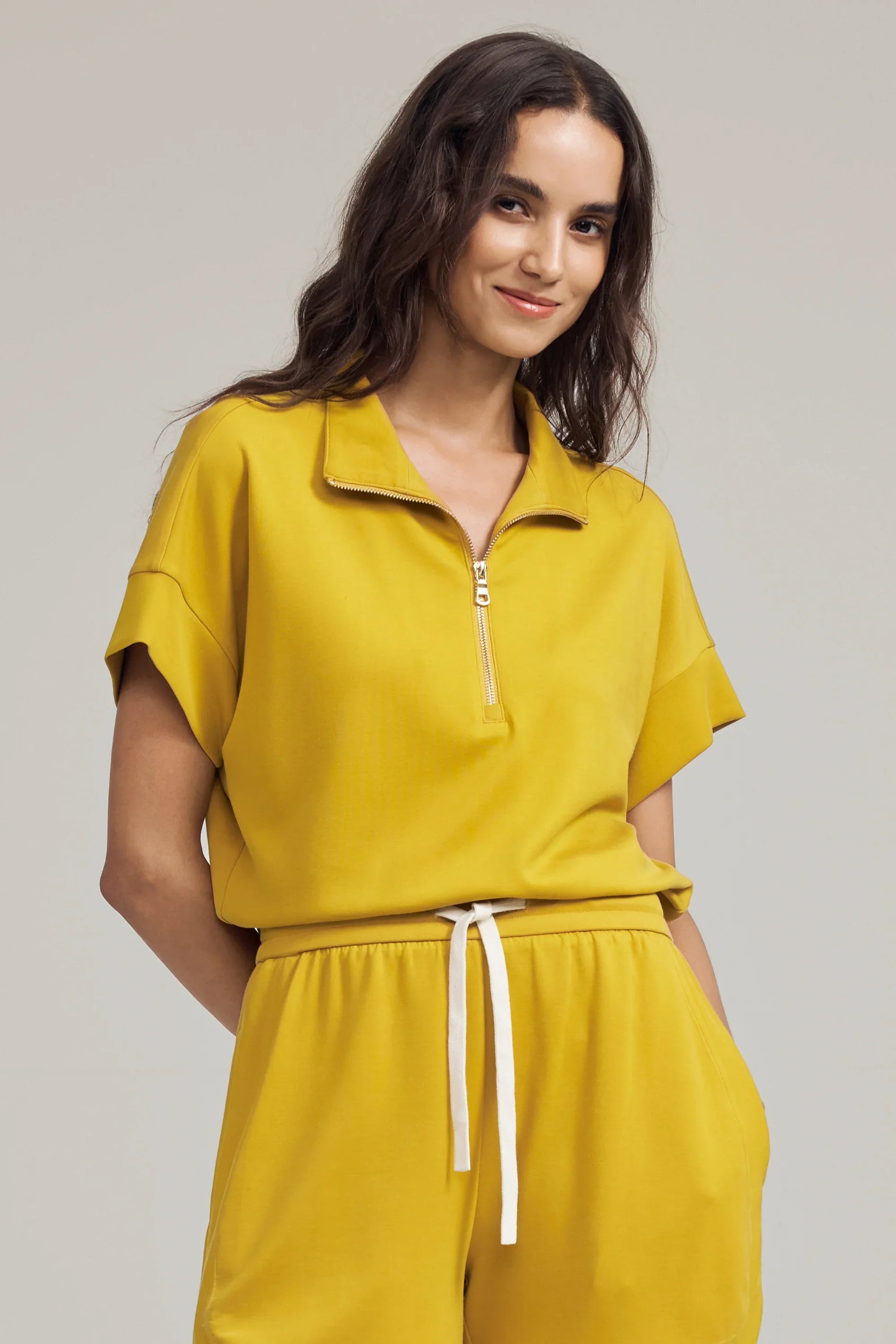 Women’s marigold performance quarter-zip top with rolled sleeves and matching shorts