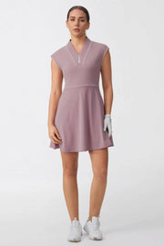 Woman wearing a soft mauve cap sleeve zip-front golf dress with contrast piping