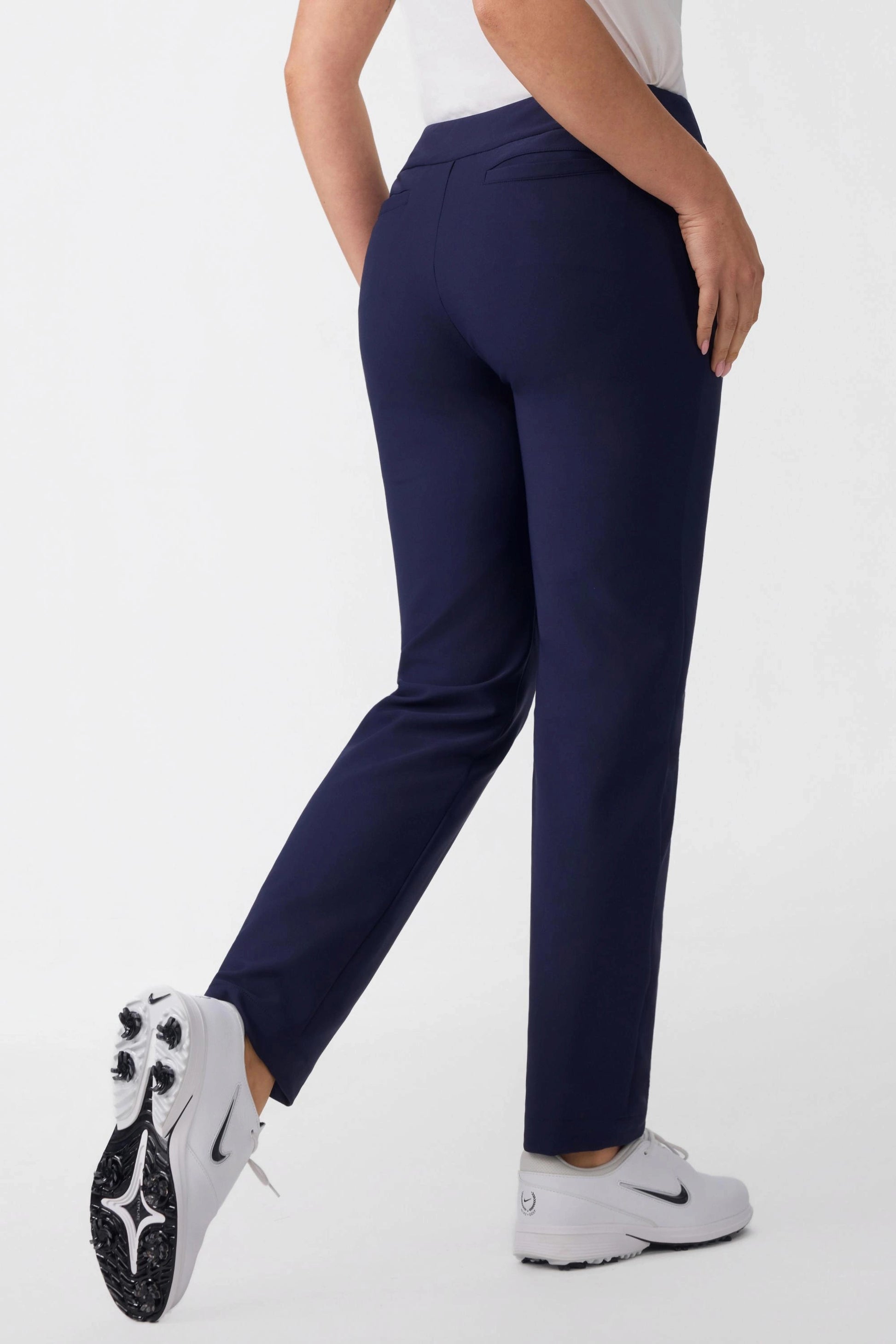 Back angled view of women’s midnight navy golf pants showing tailored rear fit