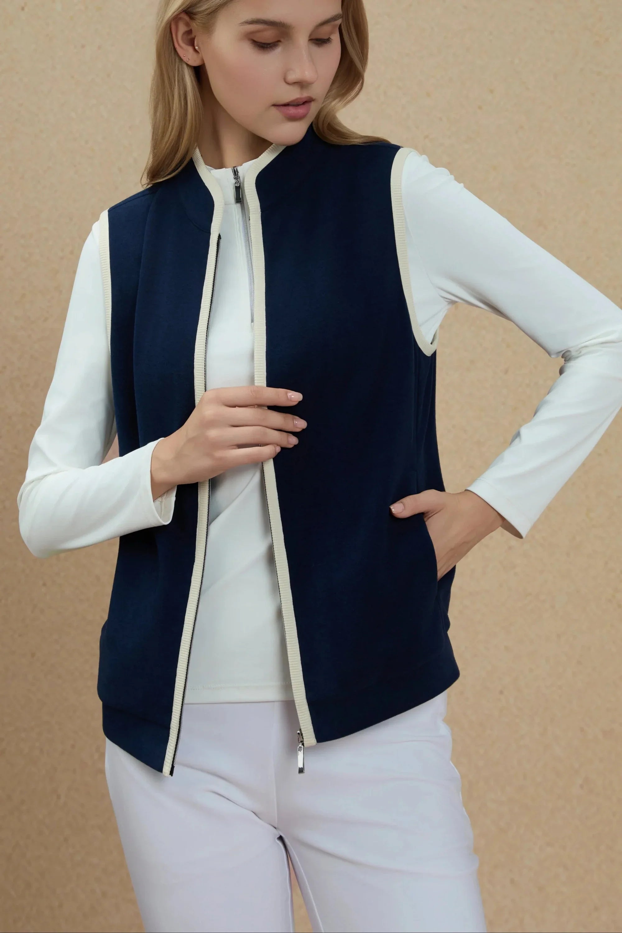 Woman wearing Women’s Midnight Navy zip-front golf vest with hand in pocket showing functional pocket design