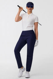 Model wearing women’s midnight navy stretch golf pants with zip pockets
