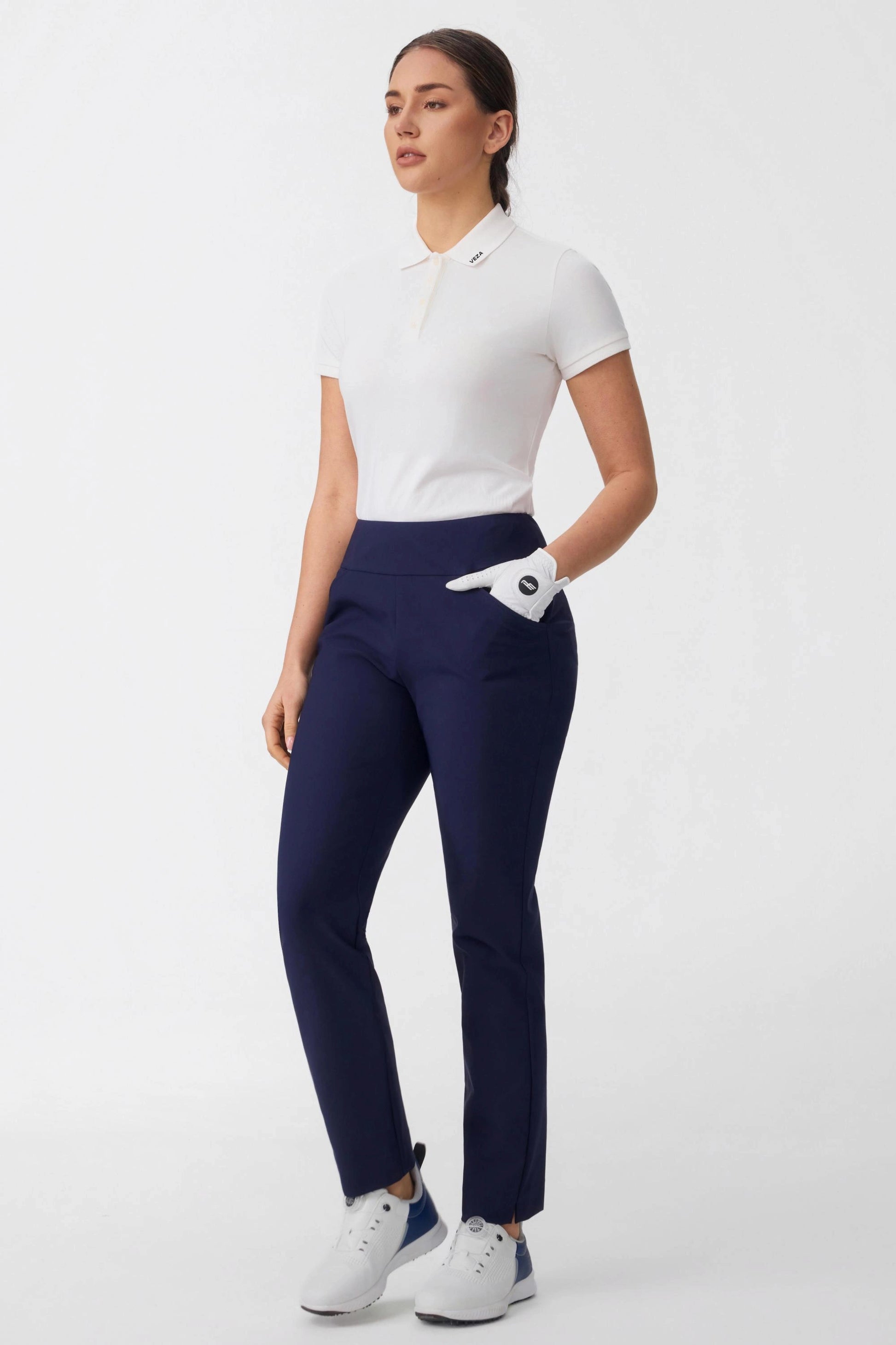 Women’s midnight navy tapered golf pants styled with white golf polo