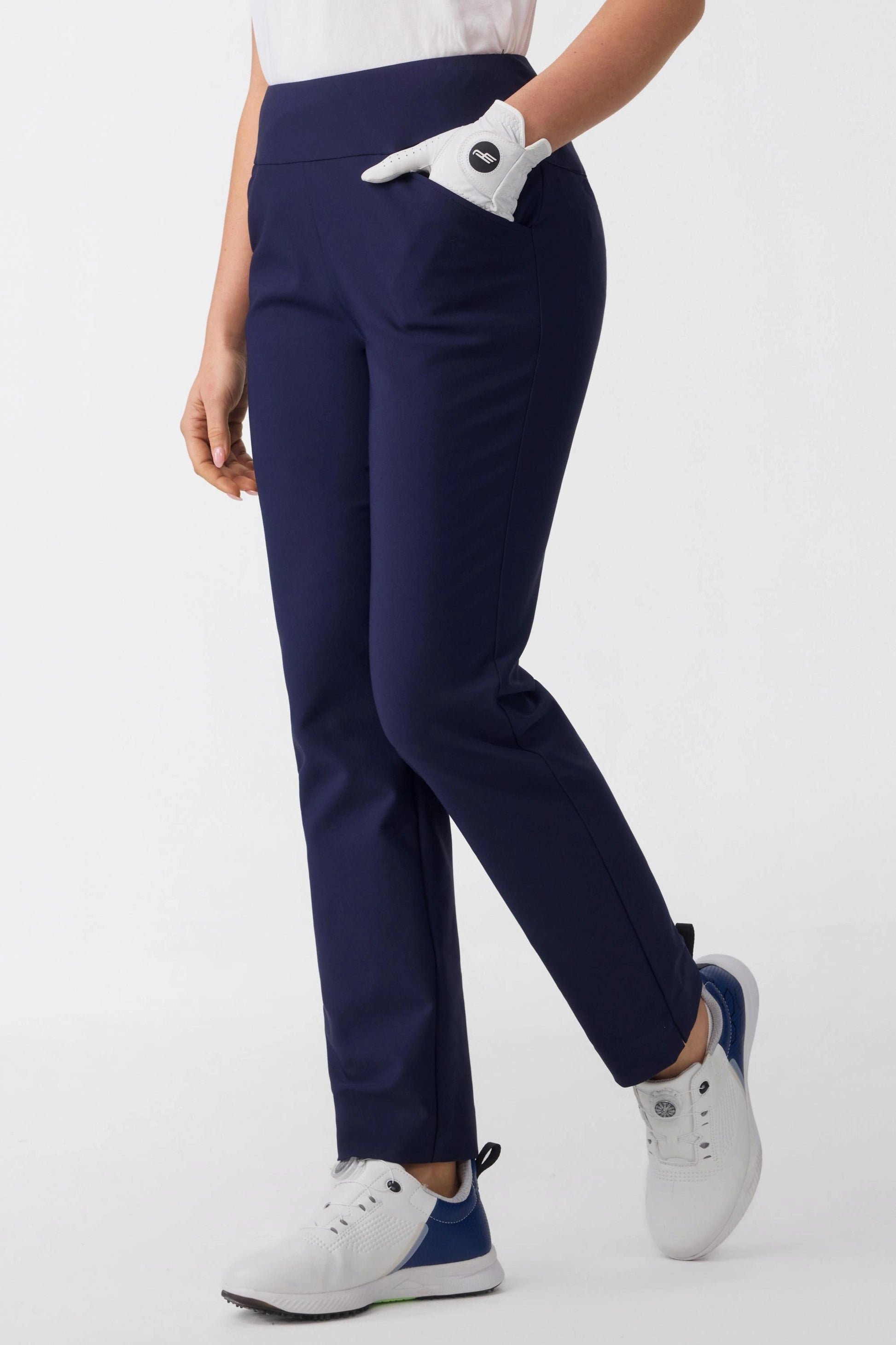Model wearing women’s midnight navy tapered golf pants with four-way stretch