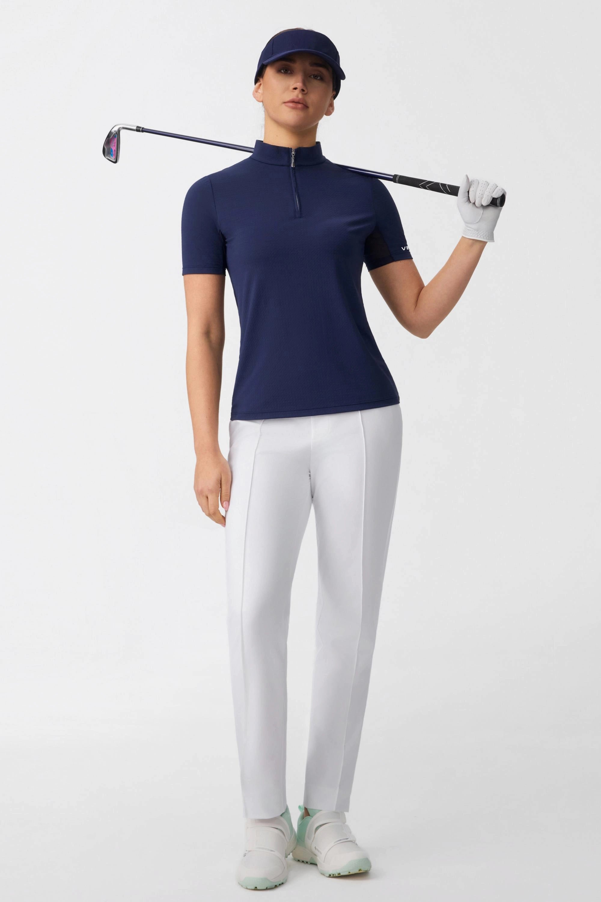 Model wearing a navy contour zip neck golf top holding a golf club, highlighting the athletic fit