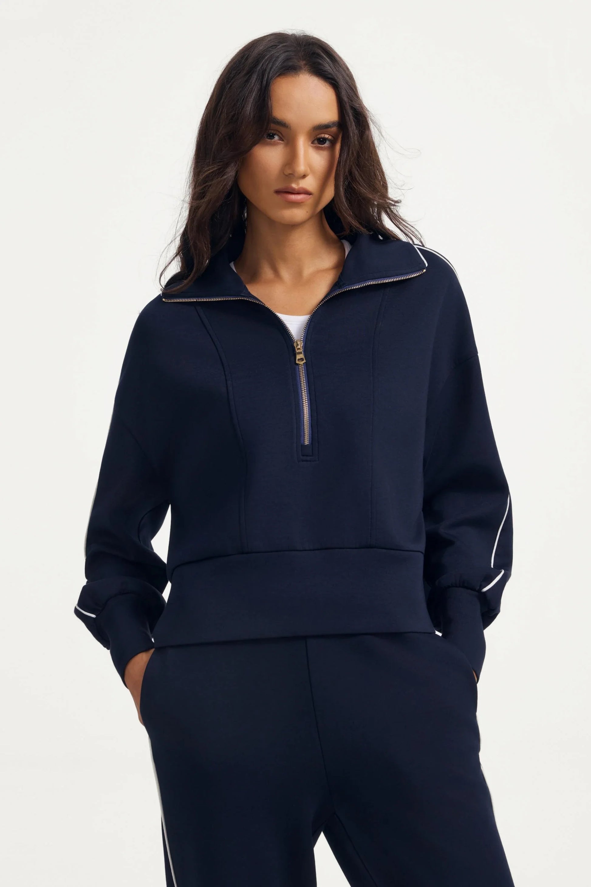 Woman wearing a women’s half-zip golf pullover in Midnight Navy with a relaxed fit and matching pants