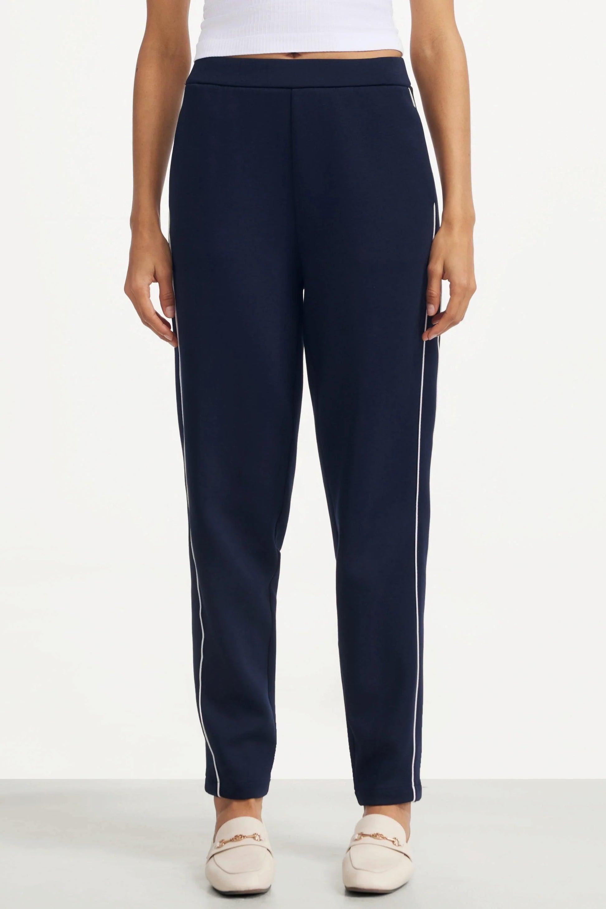Front view of women's Midnight Navy slim fit golf pants with contrast piping