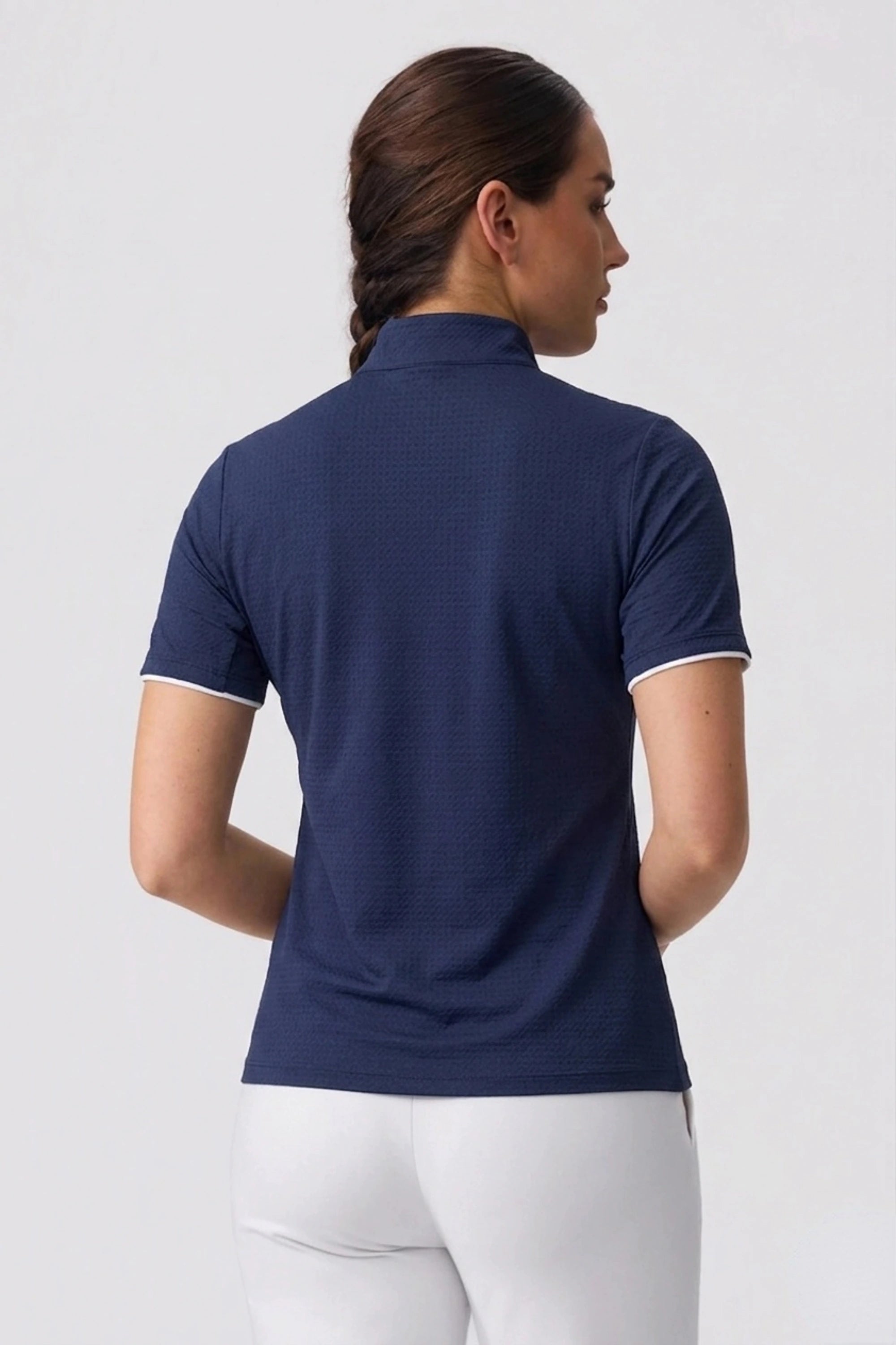 Women’s navy golf top back view featuring a clean streamlined fit and athletic design