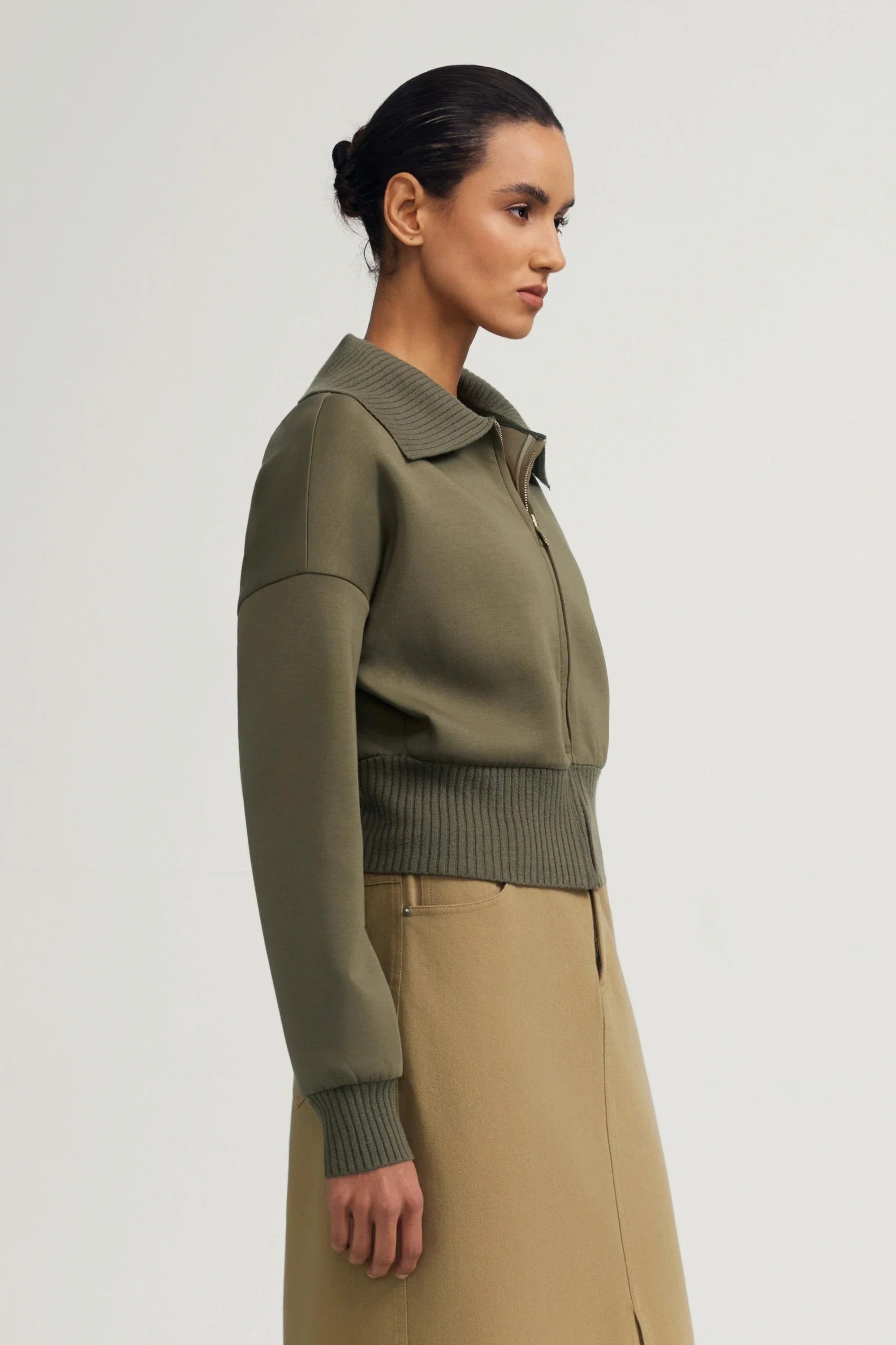 Side view of women’s olive taupe cropped knit zip jacket with structured silhouette