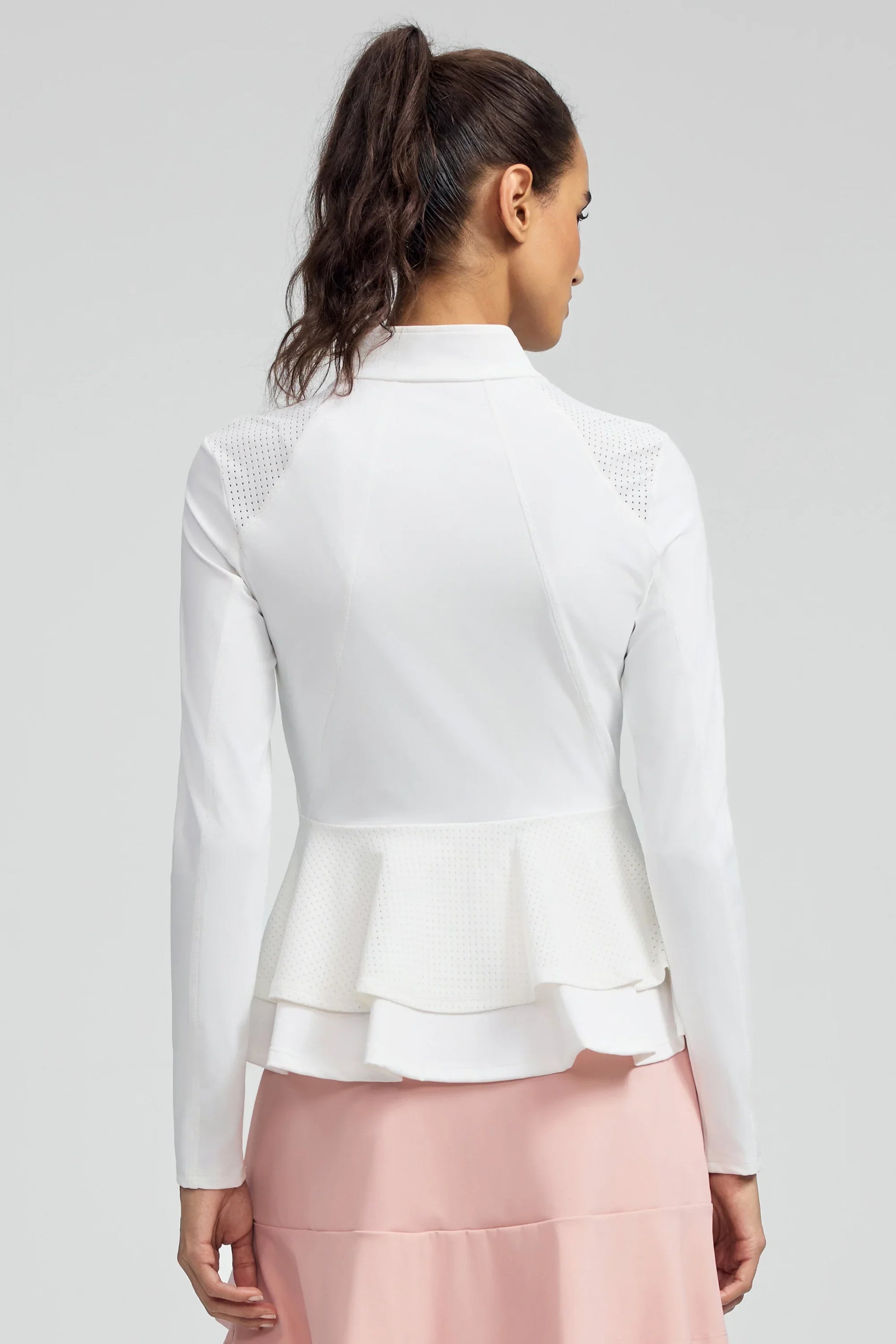 Back view of women’s white peplum mesh-panel zip golf jacket