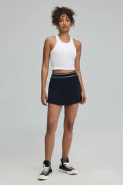 Women’s black performance golf skort on model, full-length front view