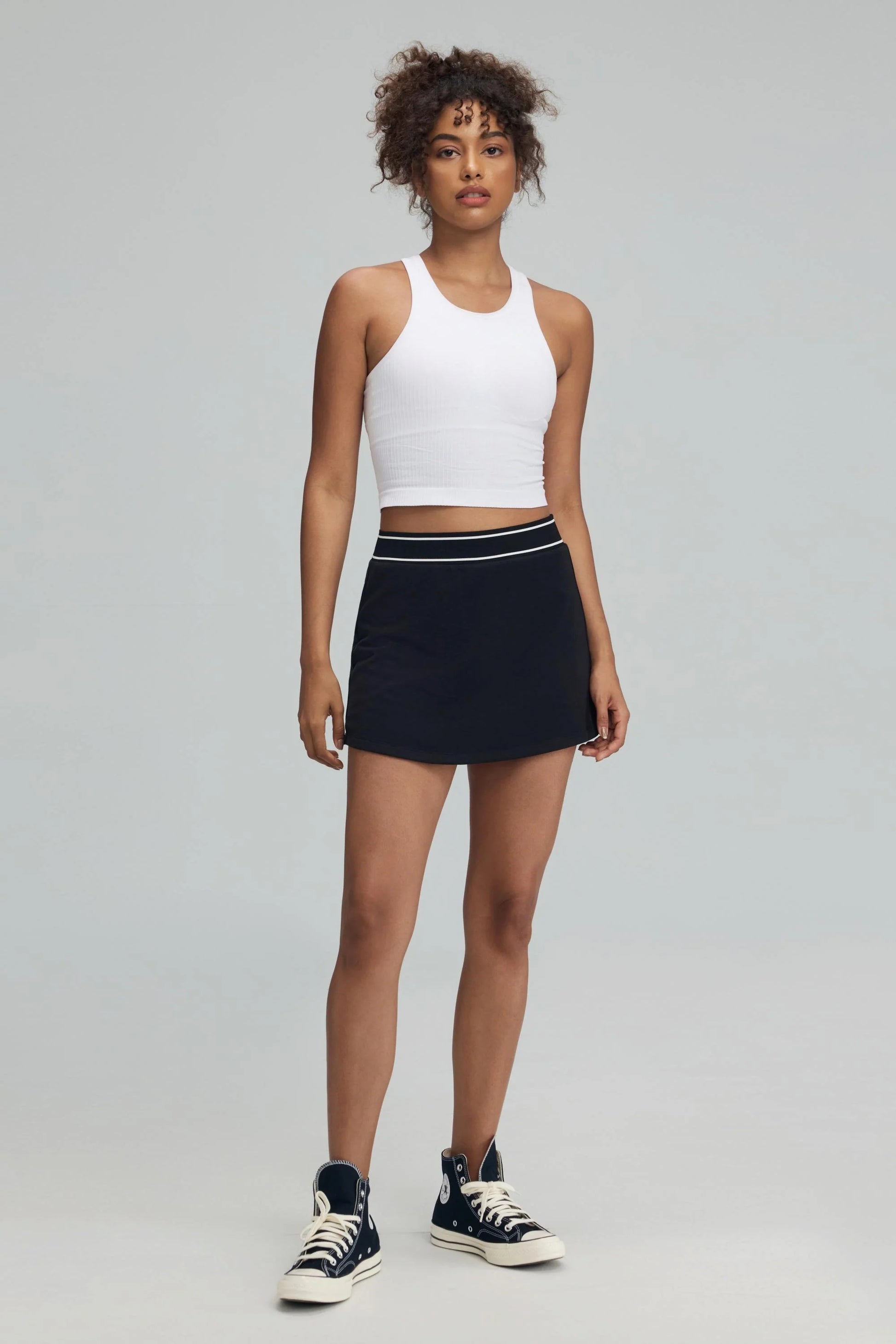 Women’s black performance golf skort on model, full-length front view