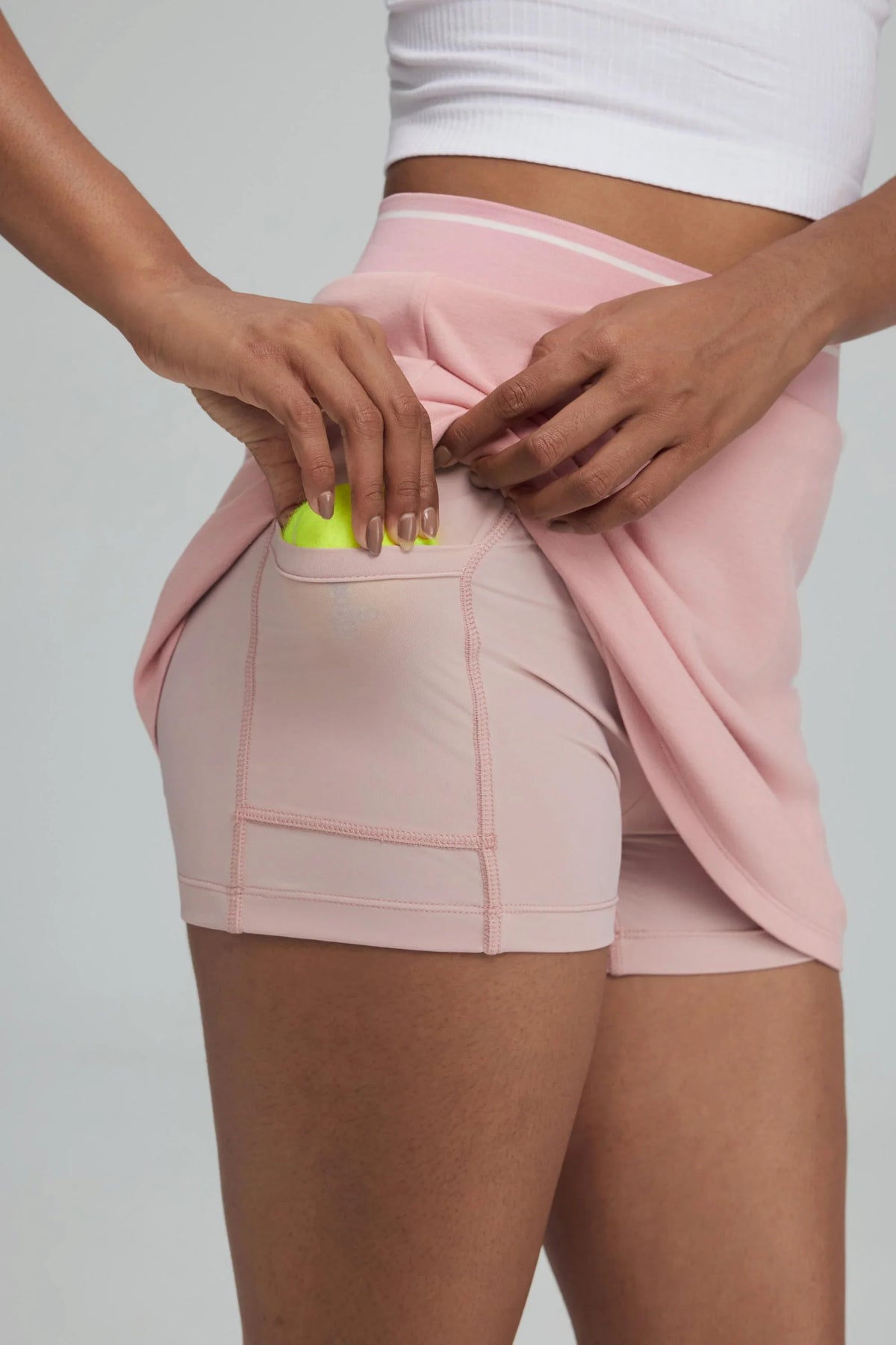 Pink women’s golf skort with built-in shorts and side ball pocket detail