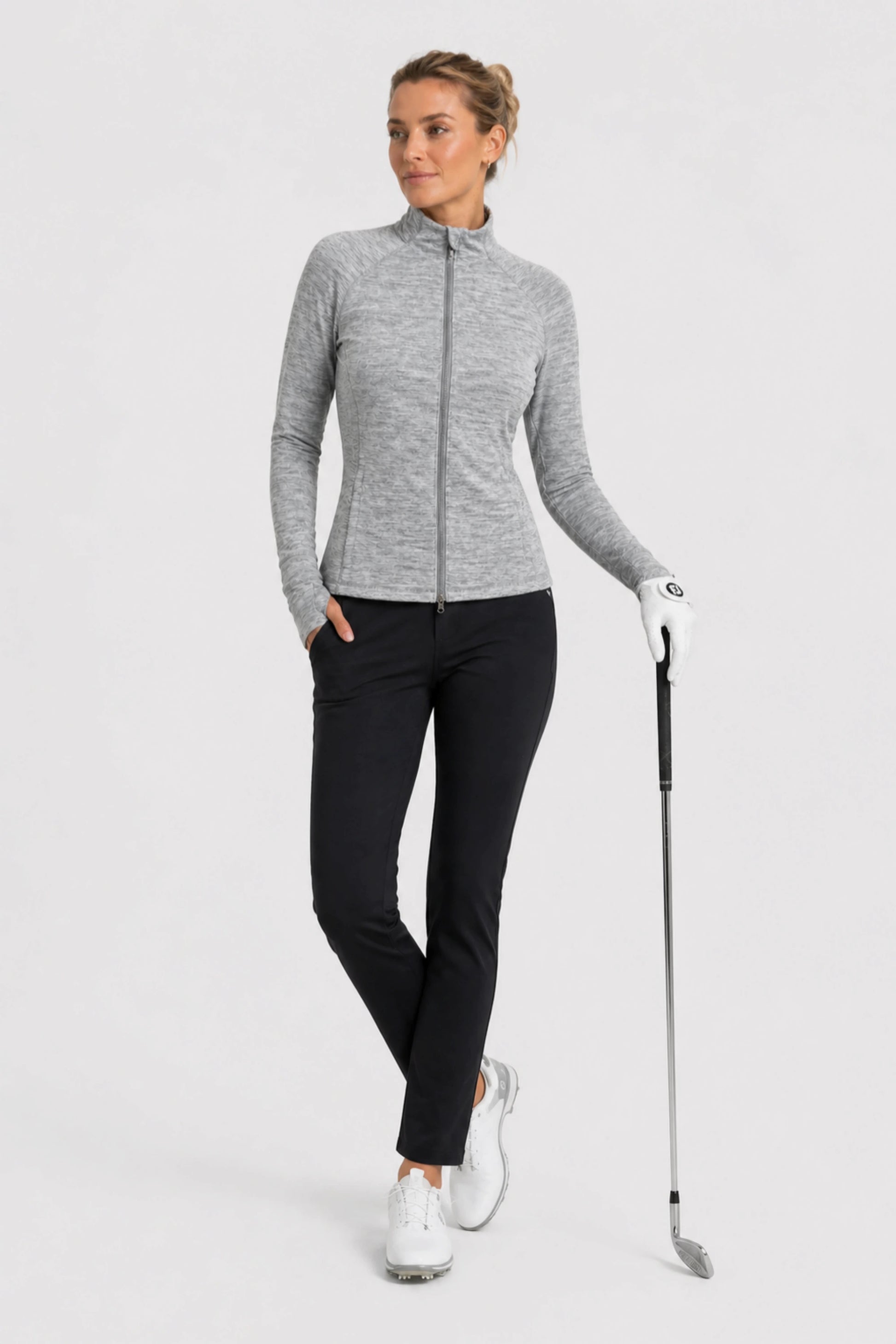 Women’s lightweight heather grey golf jacket styled with black golf pants for on-course performance