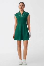 Woman wearing a pine green cap sleeve zip-front golf dress with contrast piping