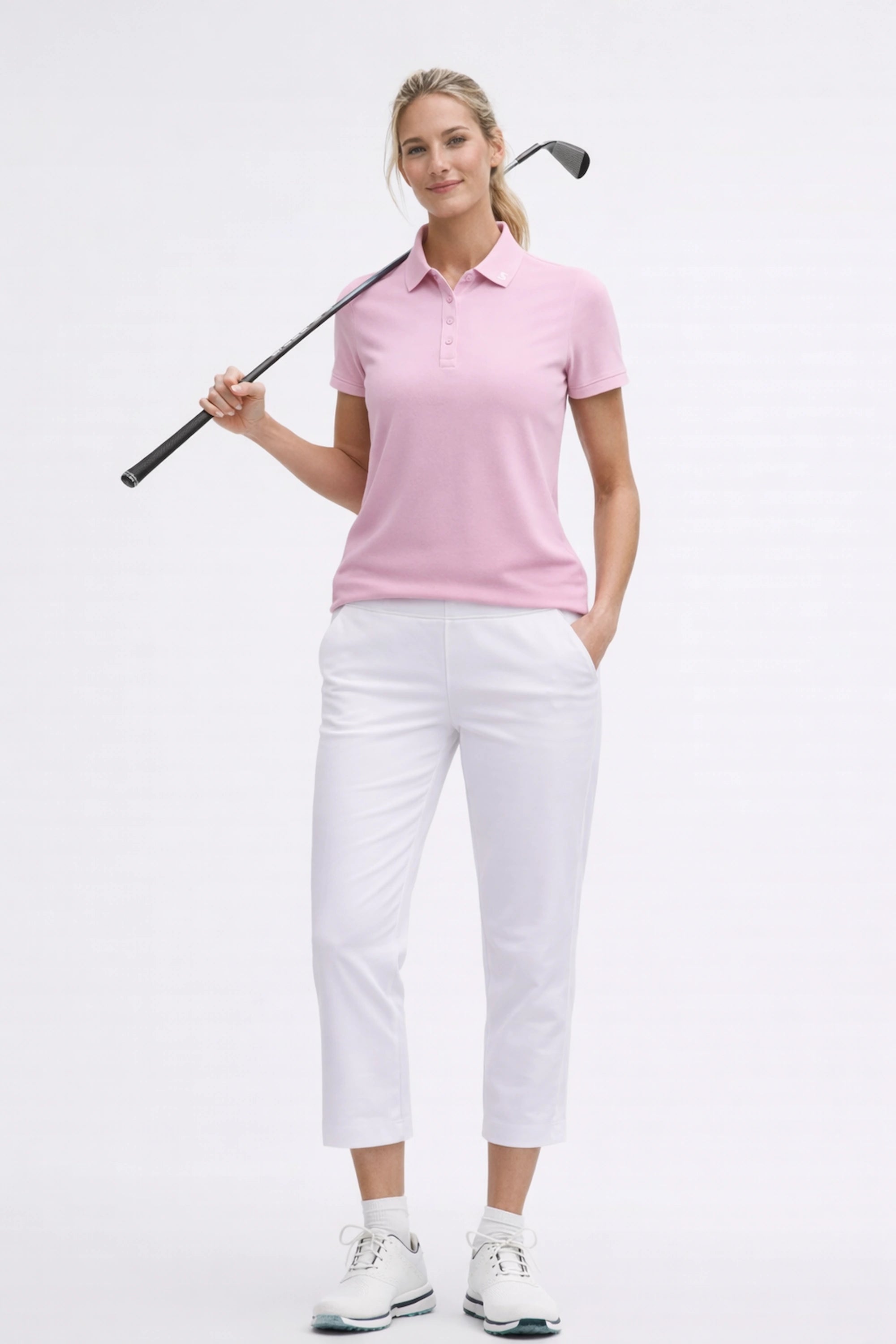 Women’s pink sculpt golf polo styled with white golf pants in a full-body golf look