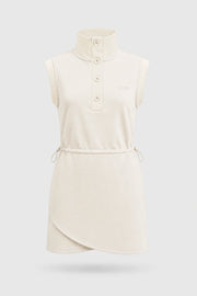 Front view of women's ivory sleeveless golf dress with buttoned stand collar, drawcord waist and asymmetric wrap hem