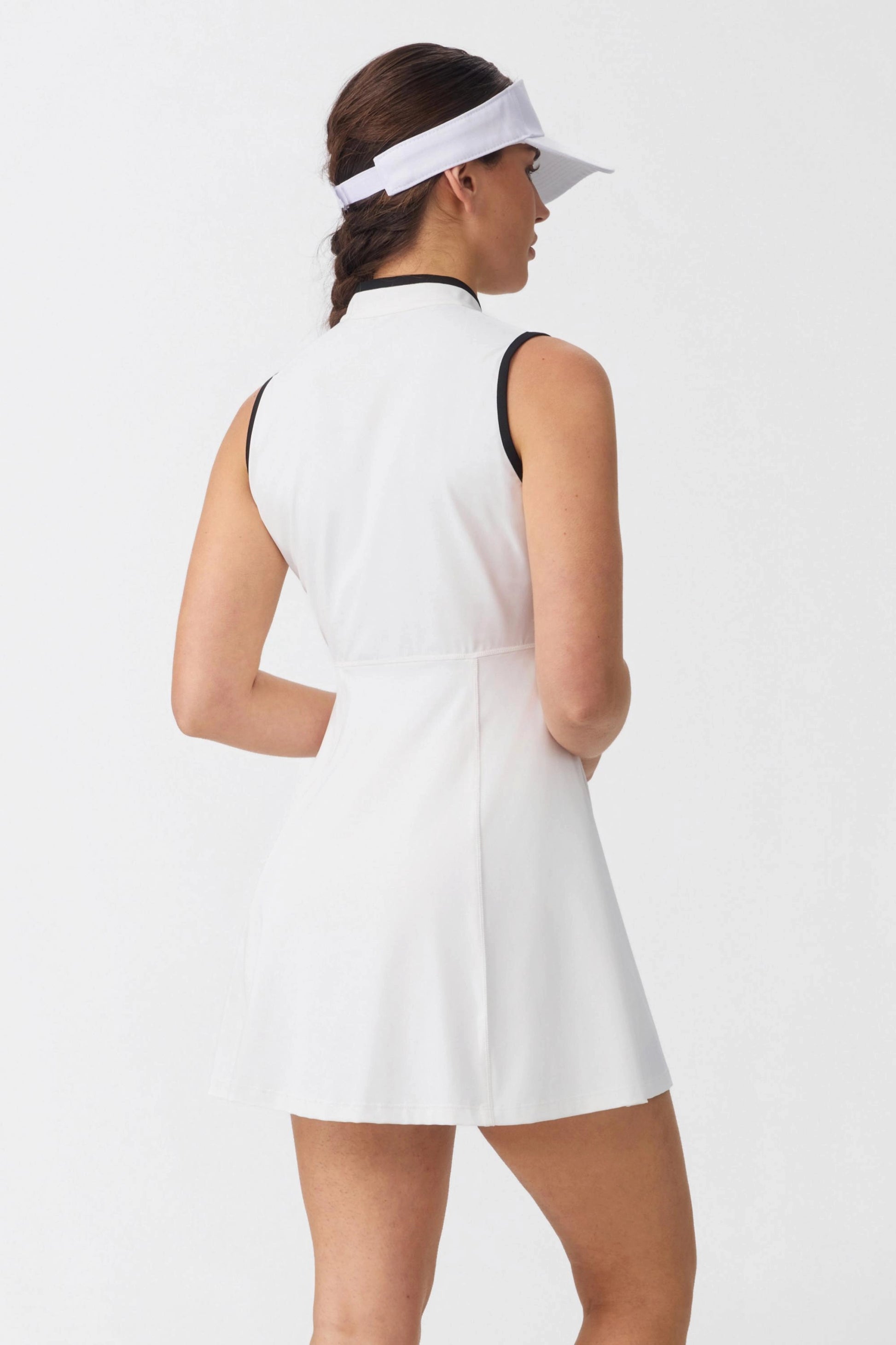Back view of women’s white sleeveless golf dress