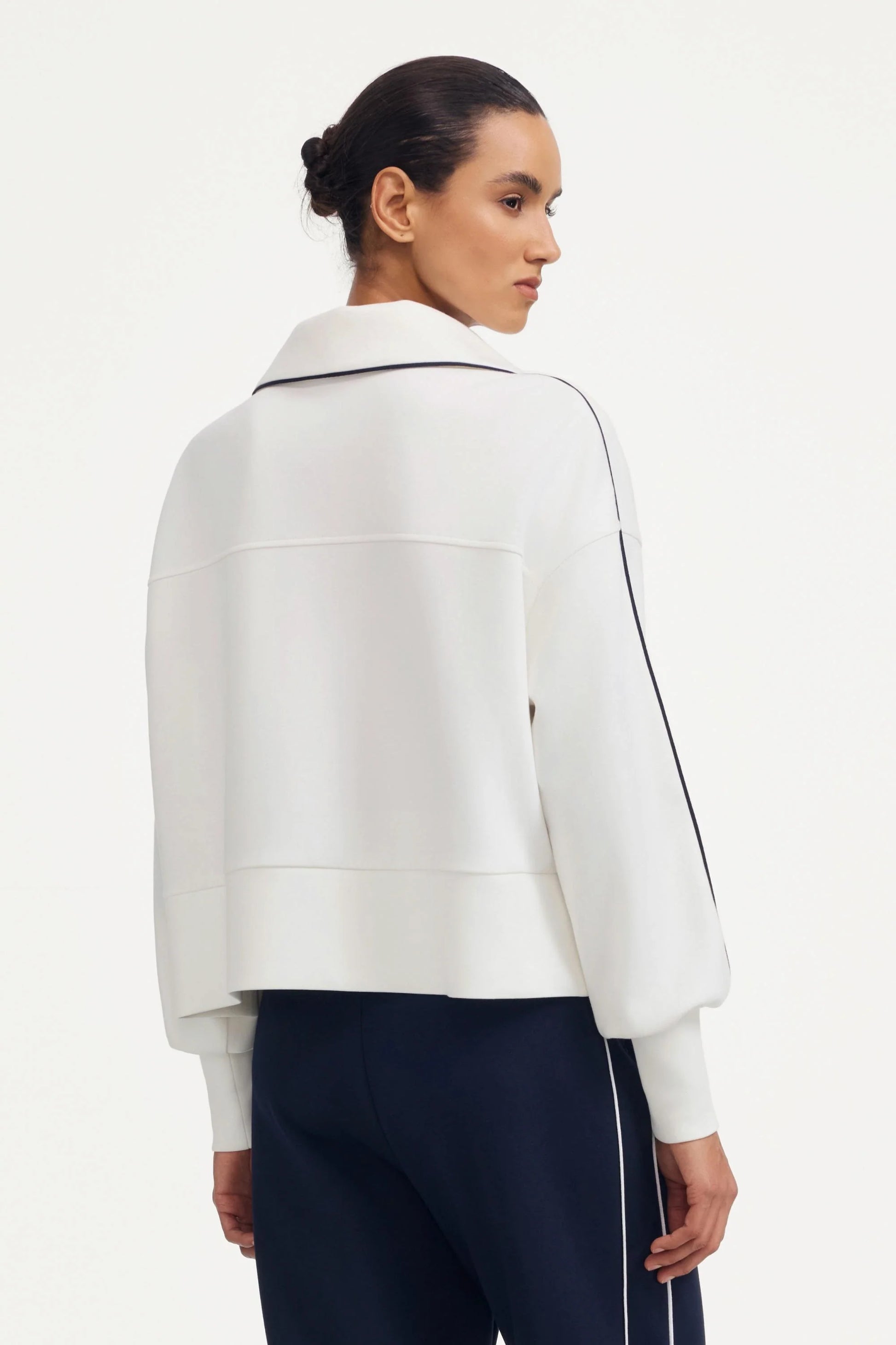 Back view of a women’s half-zip golf pullover in ivory showing the rear silhouette