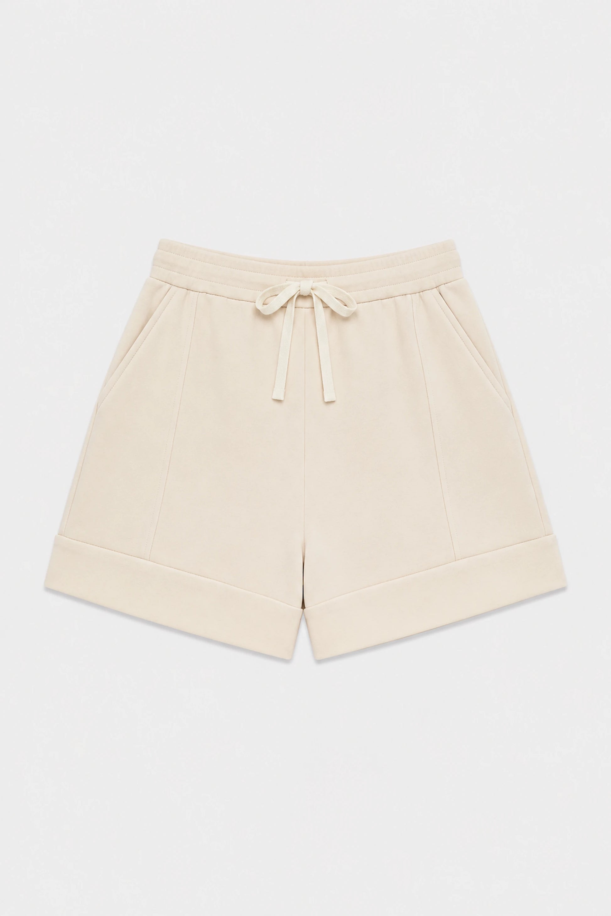 Women’s tailored golf shorts in soft oatmilk with a wide waistband and adjustable drawstring