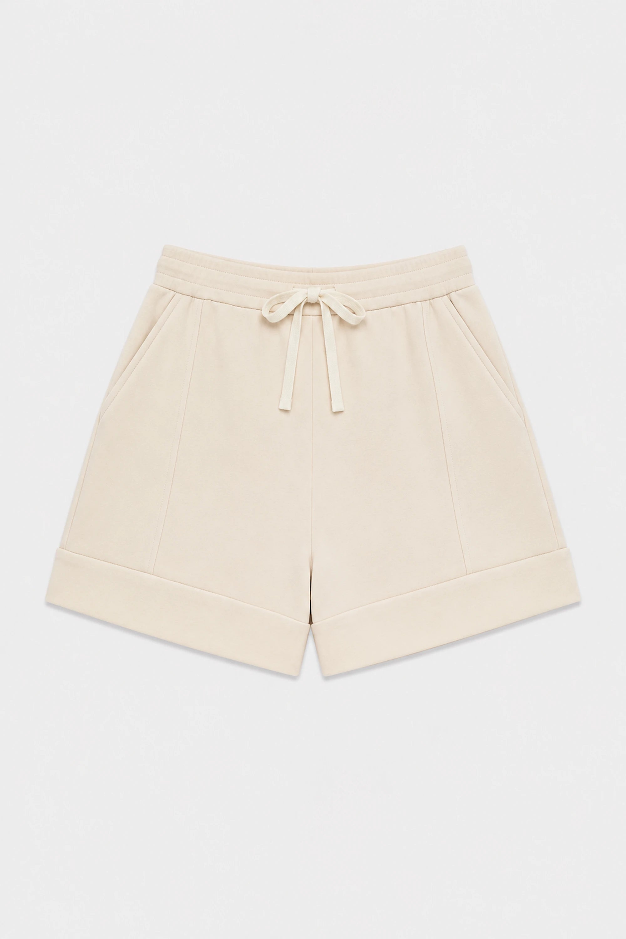 Women’s tailored golf shorts in soft oatmilk with a wide waistband and adjustable drawstring