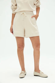 Front view of women’s tailored golf shorts in soft oatmilk with a relaxed structured silhouette