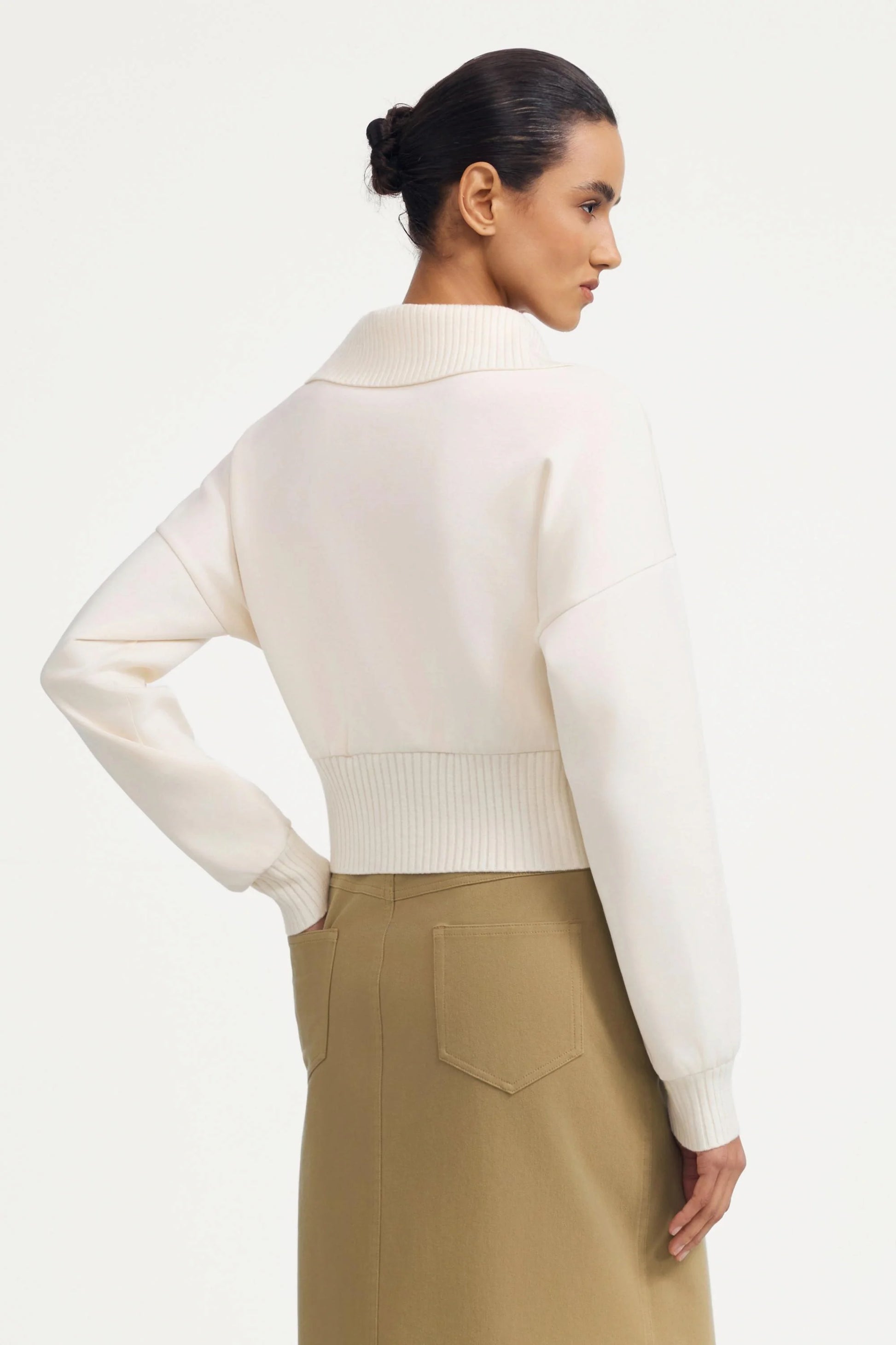 Back view of women’s soft sand cropped knit zip jacket with ribbed hem detail