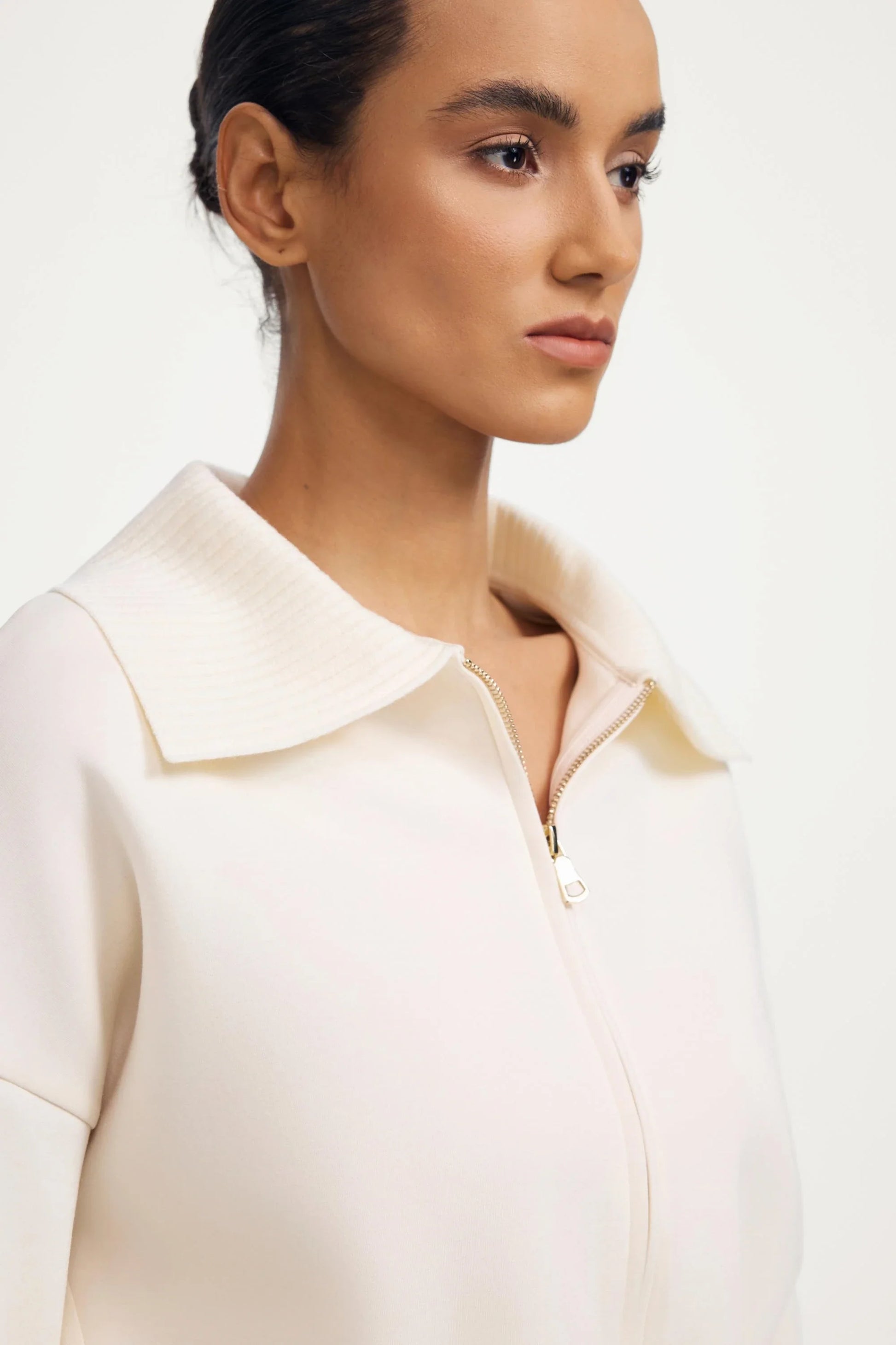 Close-up of women’s soft sand cropped knit zip jacket with zip front and structured collar