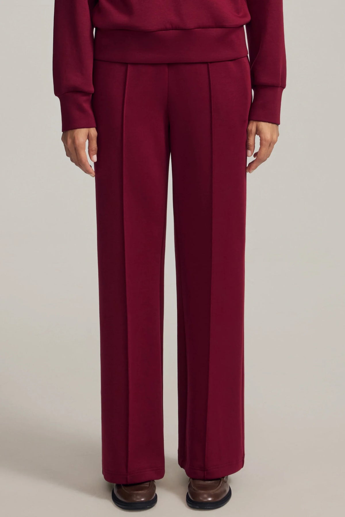 Front view of women's burgundy straight-leg pants showing clean front seams and a relaxed fit
