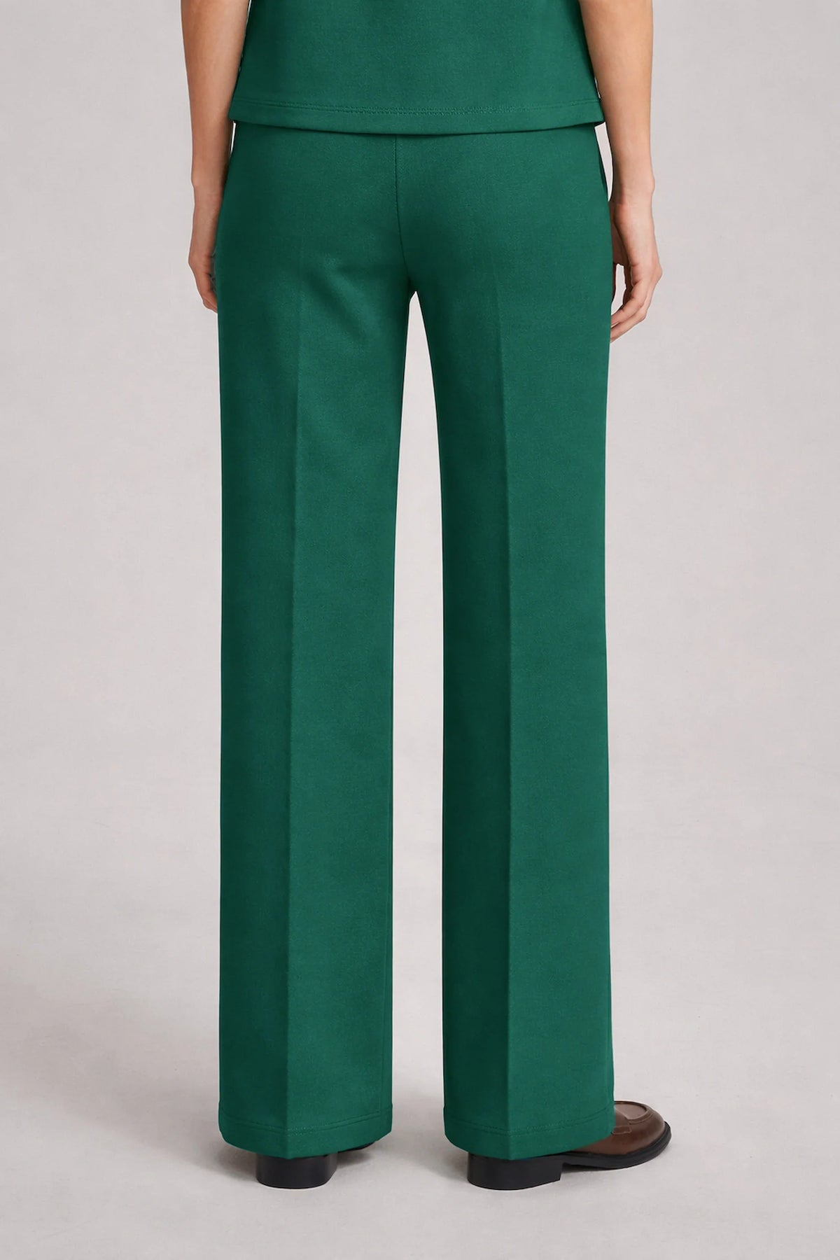 Back view of women's dark green straight-leg pants showing the clean waistband and relaxed leg silhouette