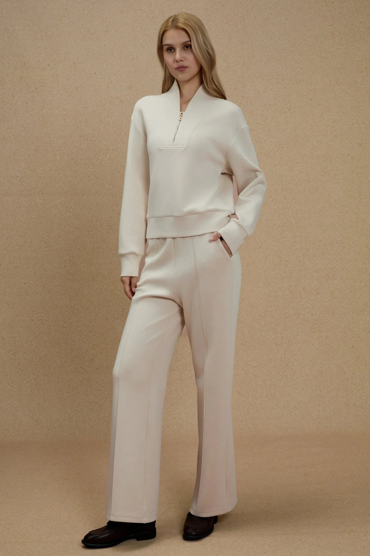 Woman wearing Oatmilk straight-leg pants styled with a matching long-sleeve top