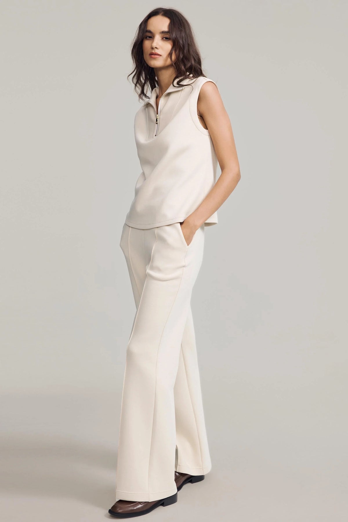Side view of a woman wearing Oatmilk straight-leg pants with a matching sleeveless top