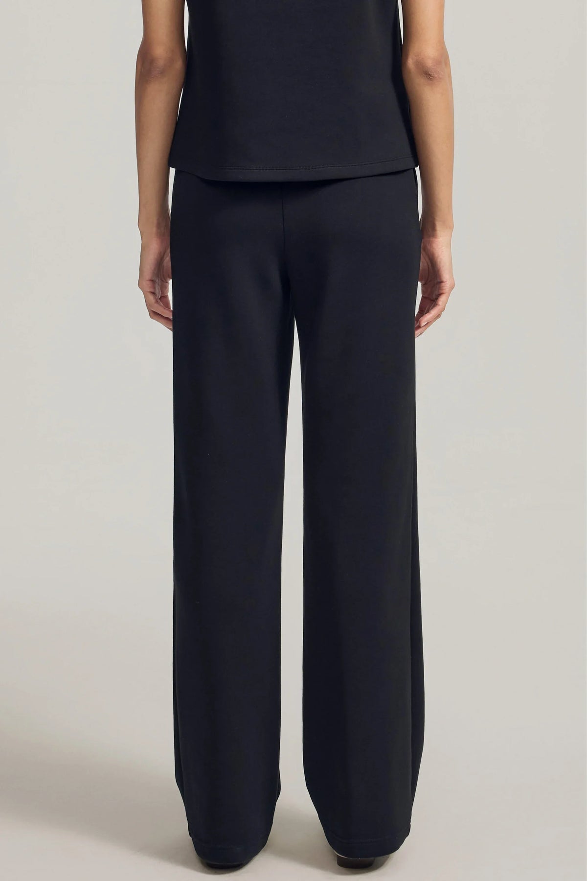 Back view of women's Onyx Black straight-leg pants with a relaxed fit and full-length design
