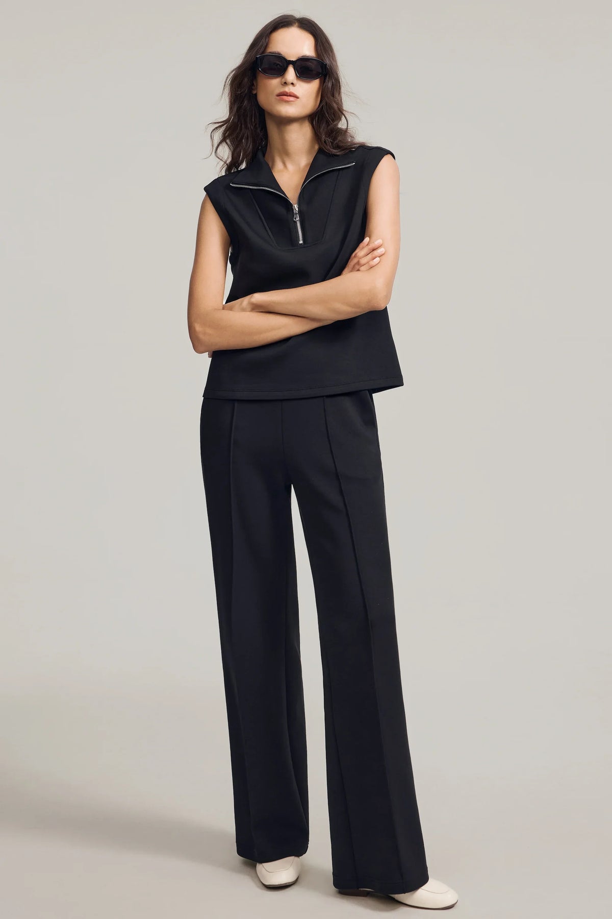 Woman wearing Onyx Black straight-leg pants with a coordinated black sleeveless top