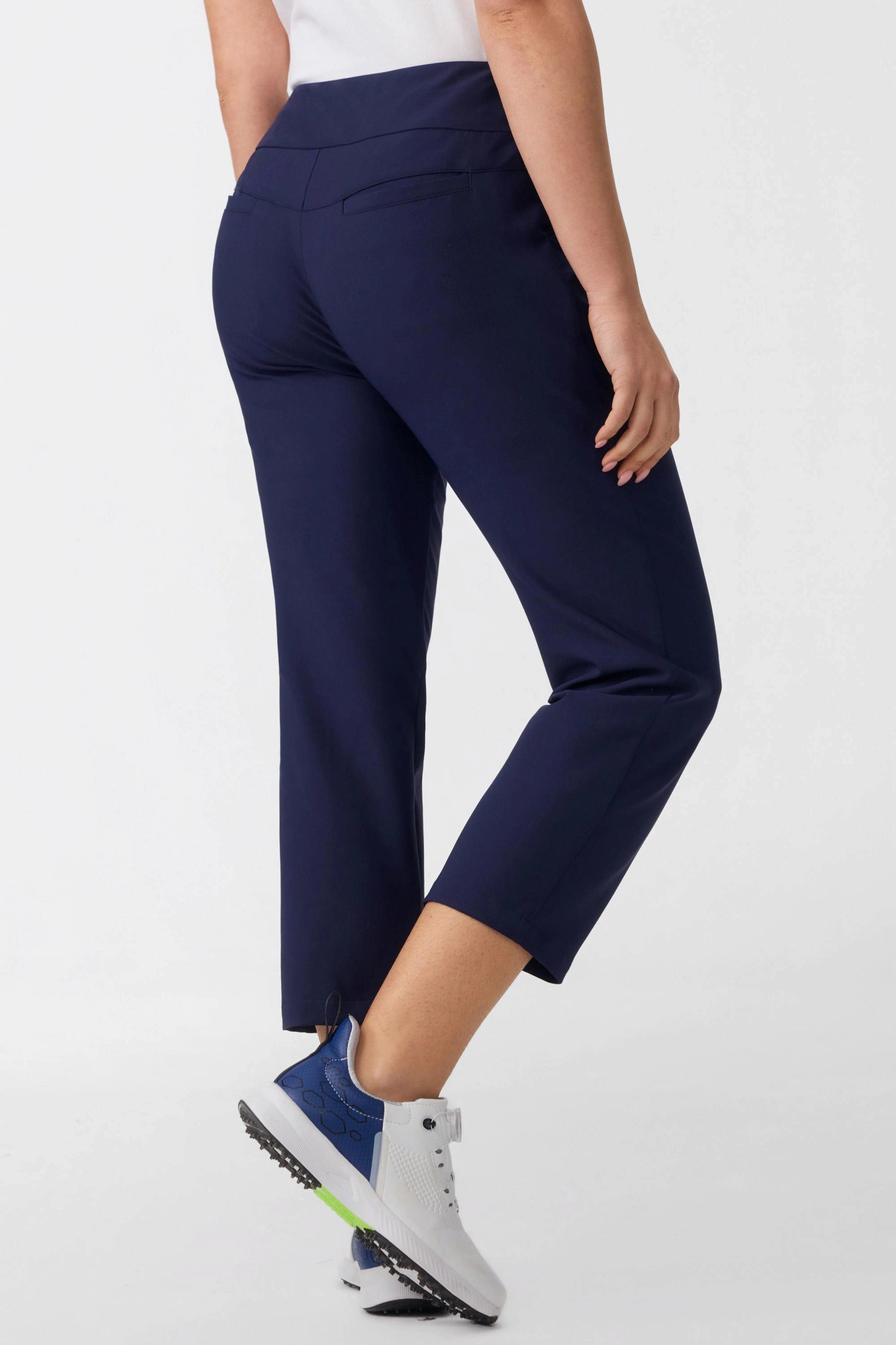 Back angled view of women’s midnight navy tailored capri golf pants showing a clean fitted silhouette