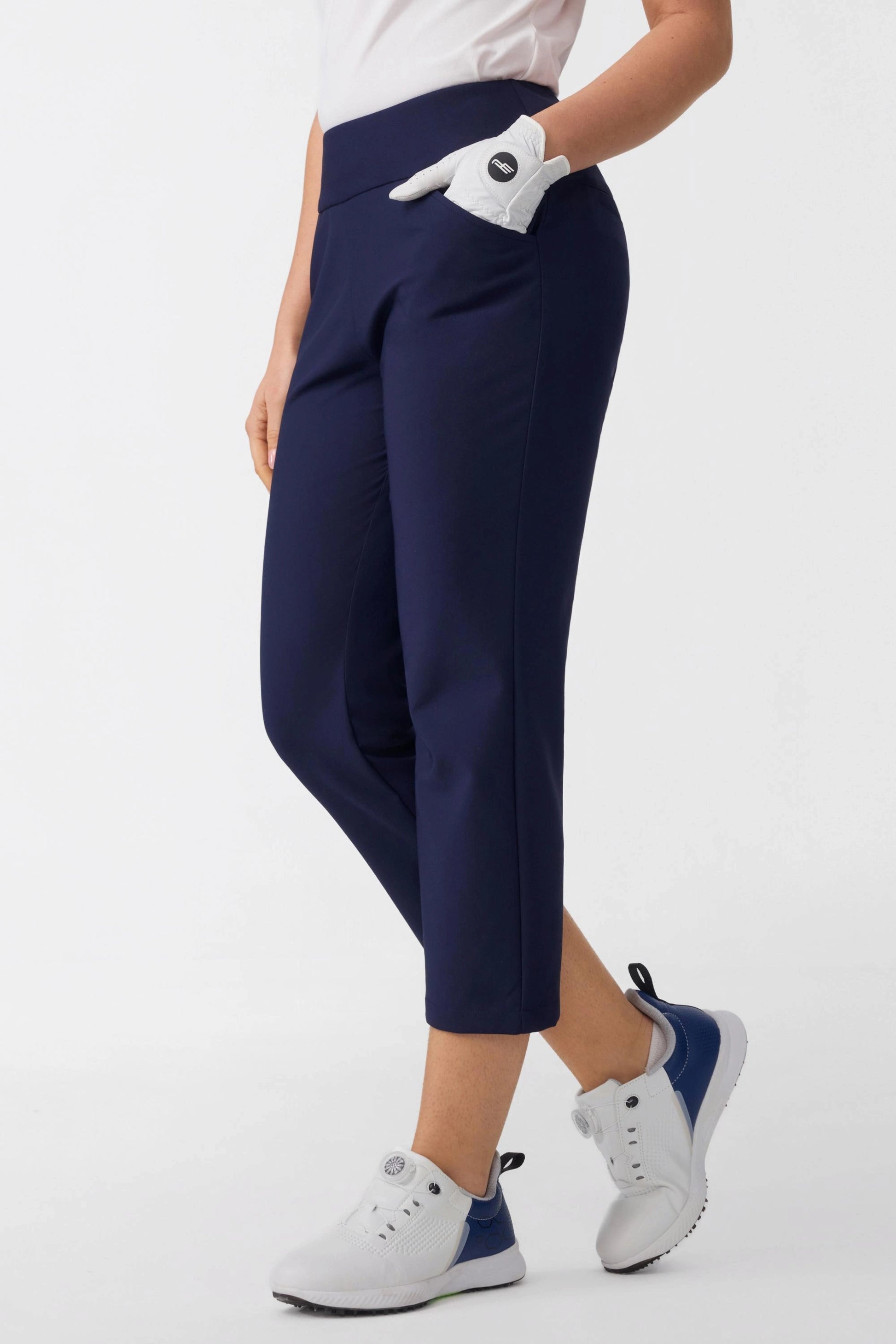 Angled front view of women’s midnight navy tailored capri golf pants with a smooth pull-on waistband