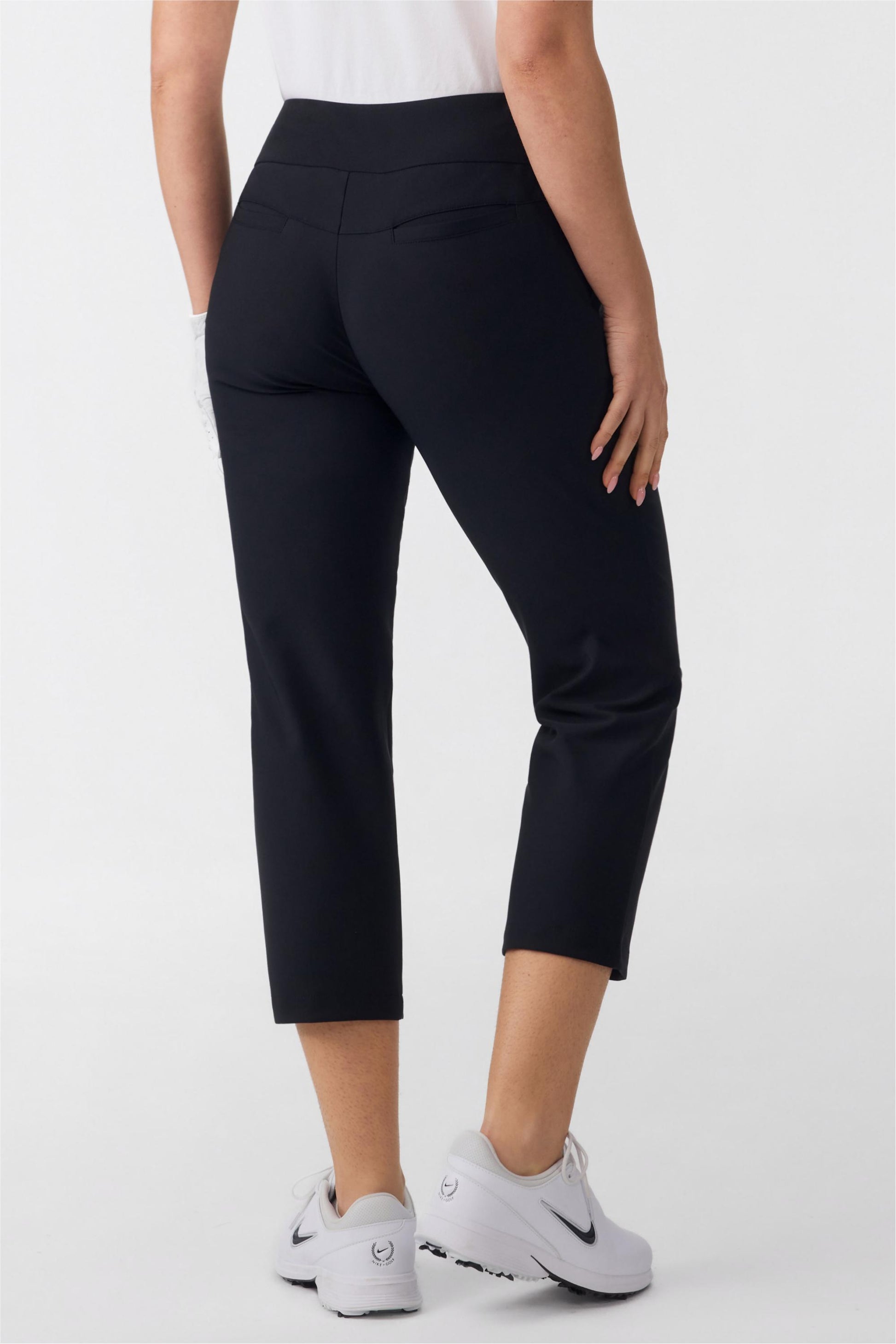 Back view of women’s tailored capri golf pants in onyx black with clean waistband and back pocket detail