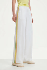 Side detail of women’s classic white wide-leg pants with yellow and green side stripes