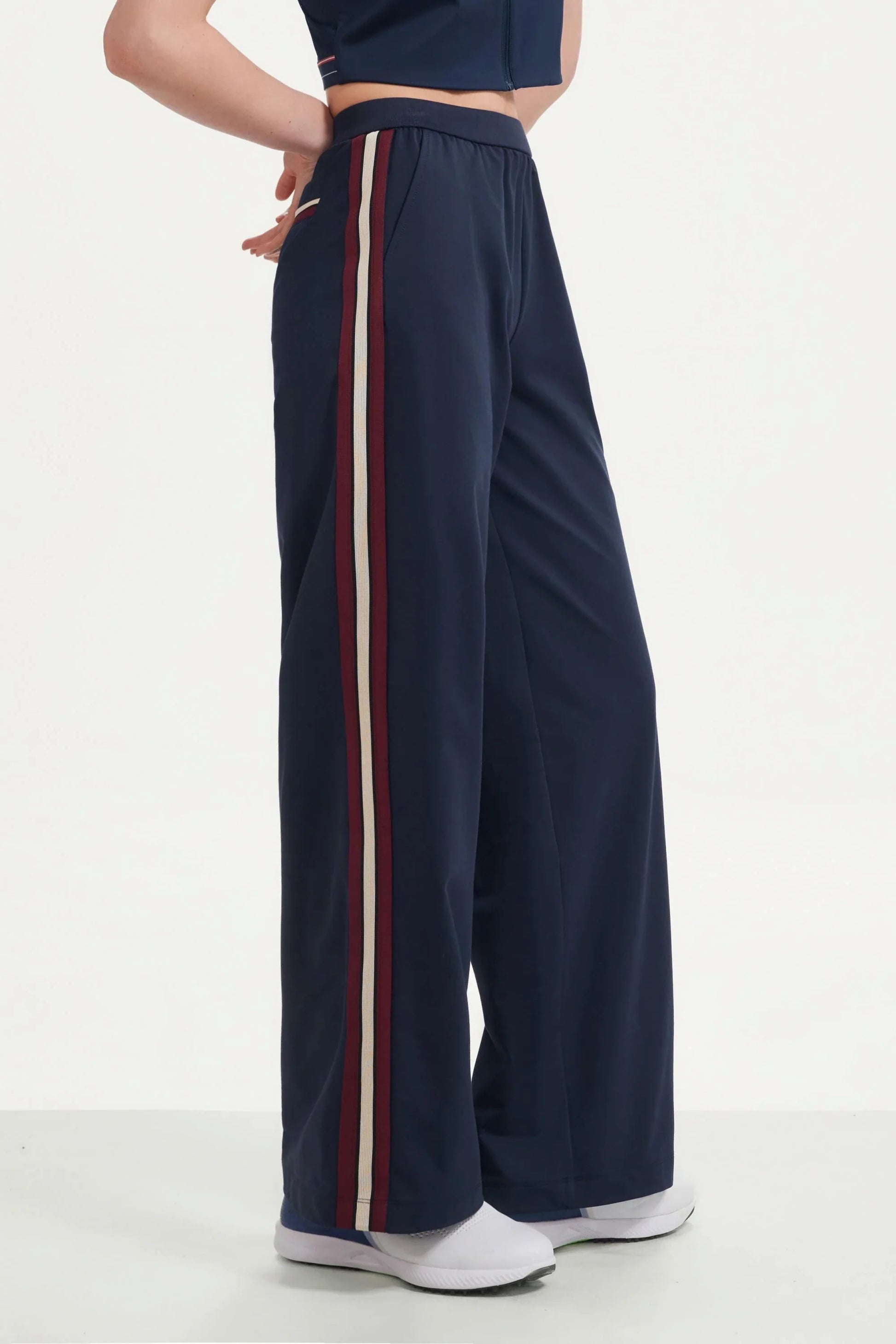 Women’s midnight navy wide-leg pants with contrast side stripes shown from the side