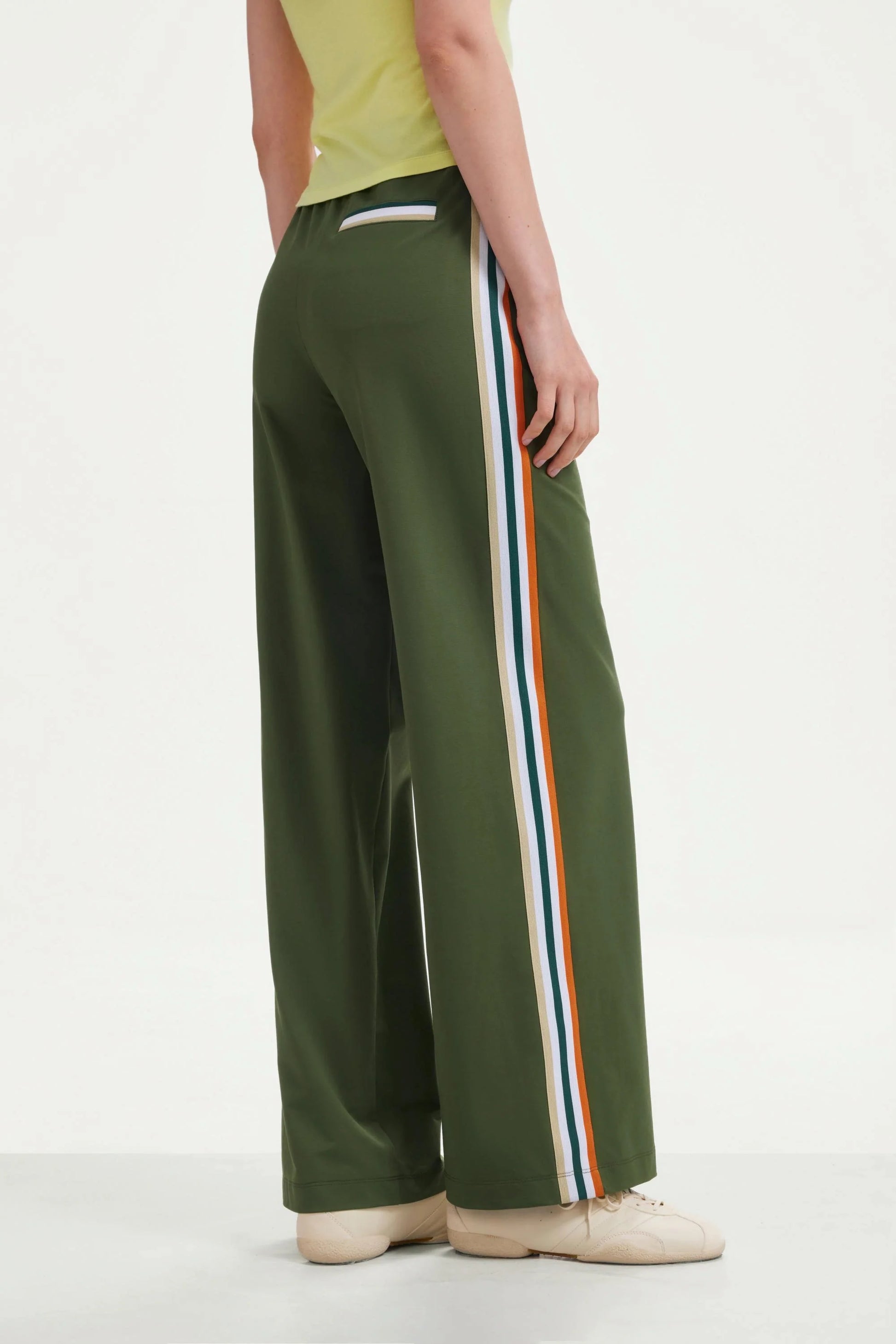 Back view of women’s olive green wide-leg pants with side stripes and back pocket detail