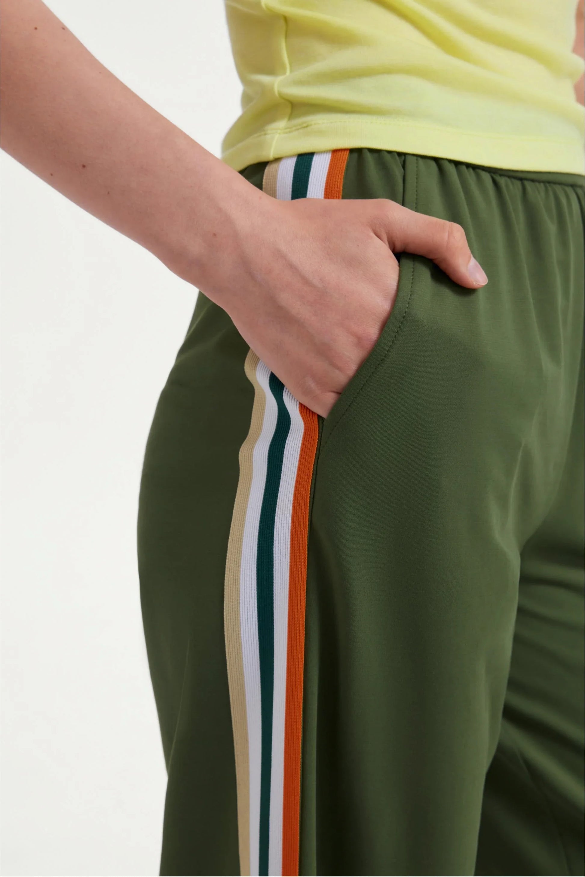 Pocket detail of women’s olive green wide-leg pants with multicolor side stripes