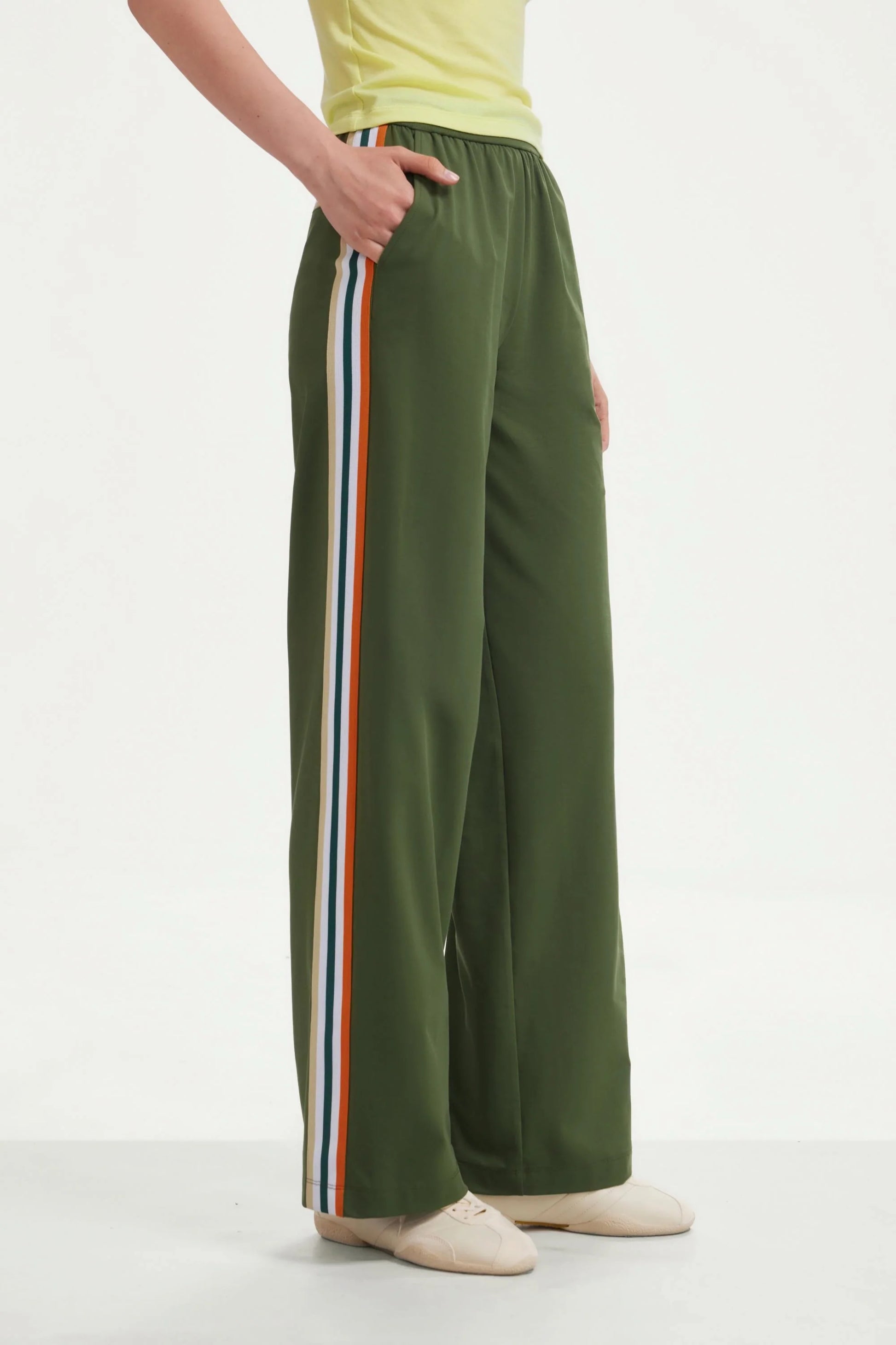 Side view of women’s olive green wide-leg pants with contrast side stripes