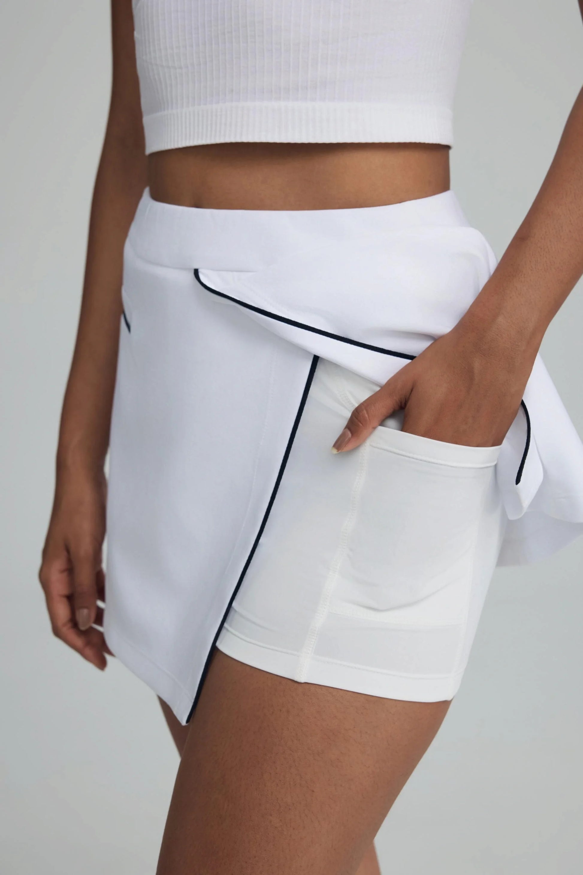 Detail of built-in shorts and pocket inside women’s crisp white wrap front golf skort