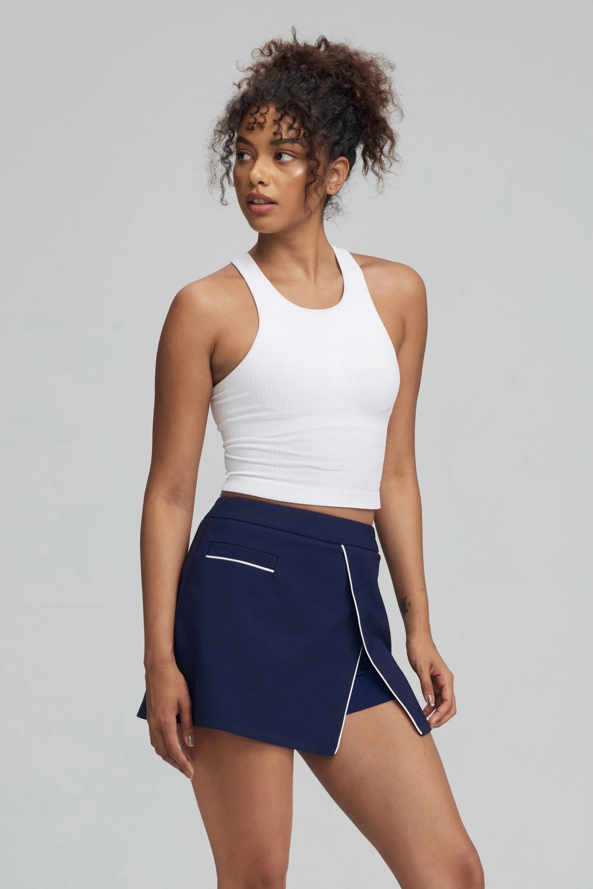 Front view of women's Midnight Navy wrap golf skort with white piping along the overlapping skirt panels
