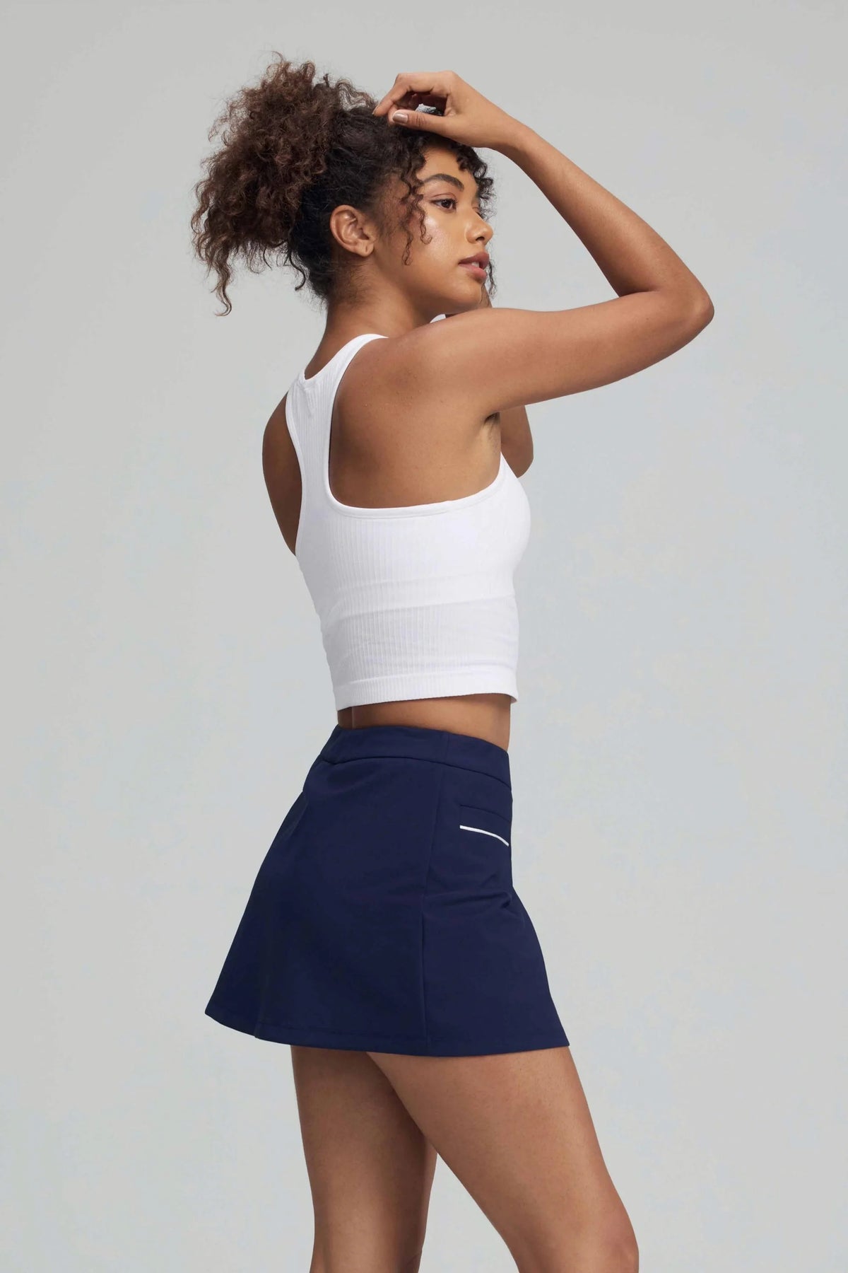 Side back view of women's Midnight Navy wrap front golf skort showing the clean skirt silhouette